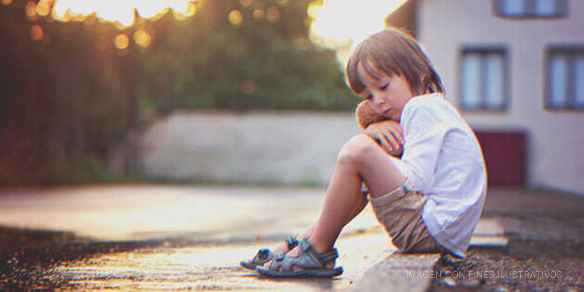 Niño con rostro triste sentado en una acera. | Foto: Shutterstock