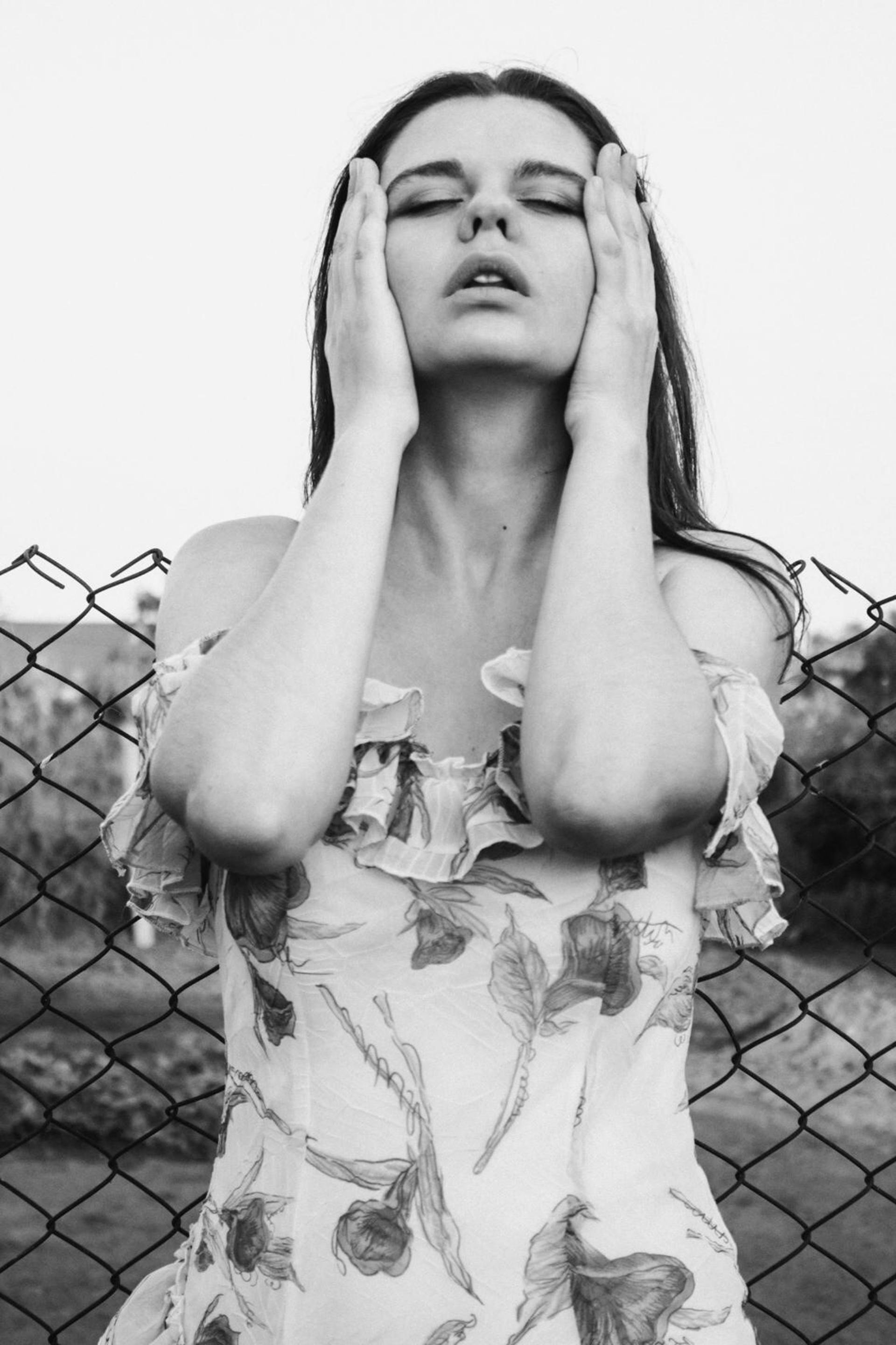 Foto en escala de grises de una mujer con las manos en la cara | Fuente: Pexels