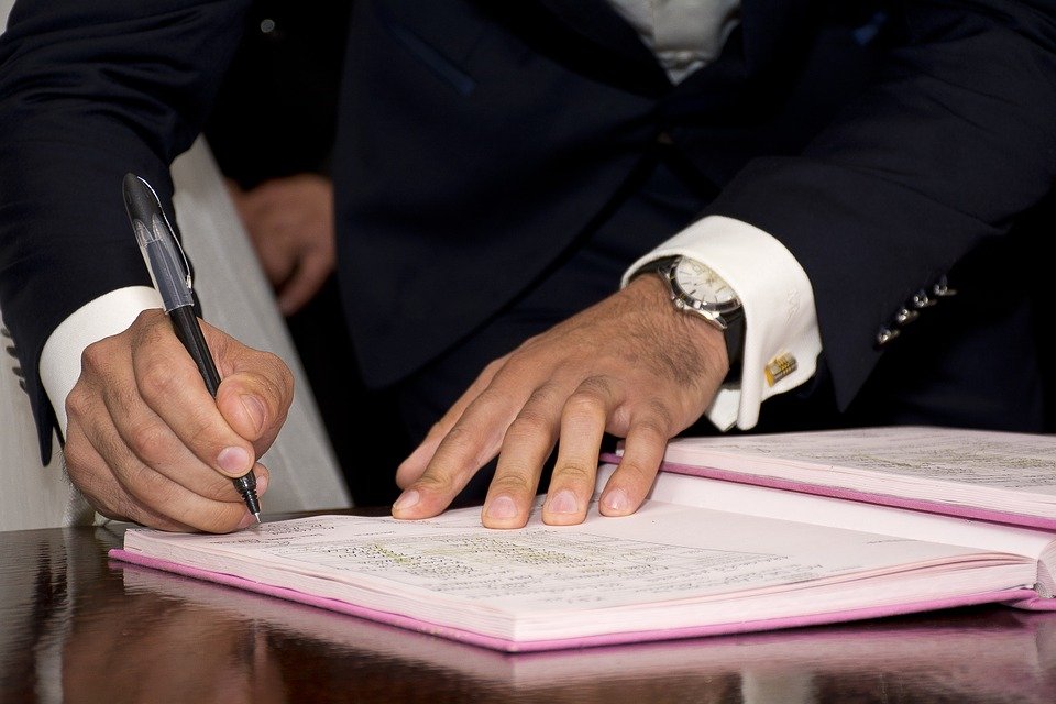Hombre firmando un documento. | Foto: Pixabay