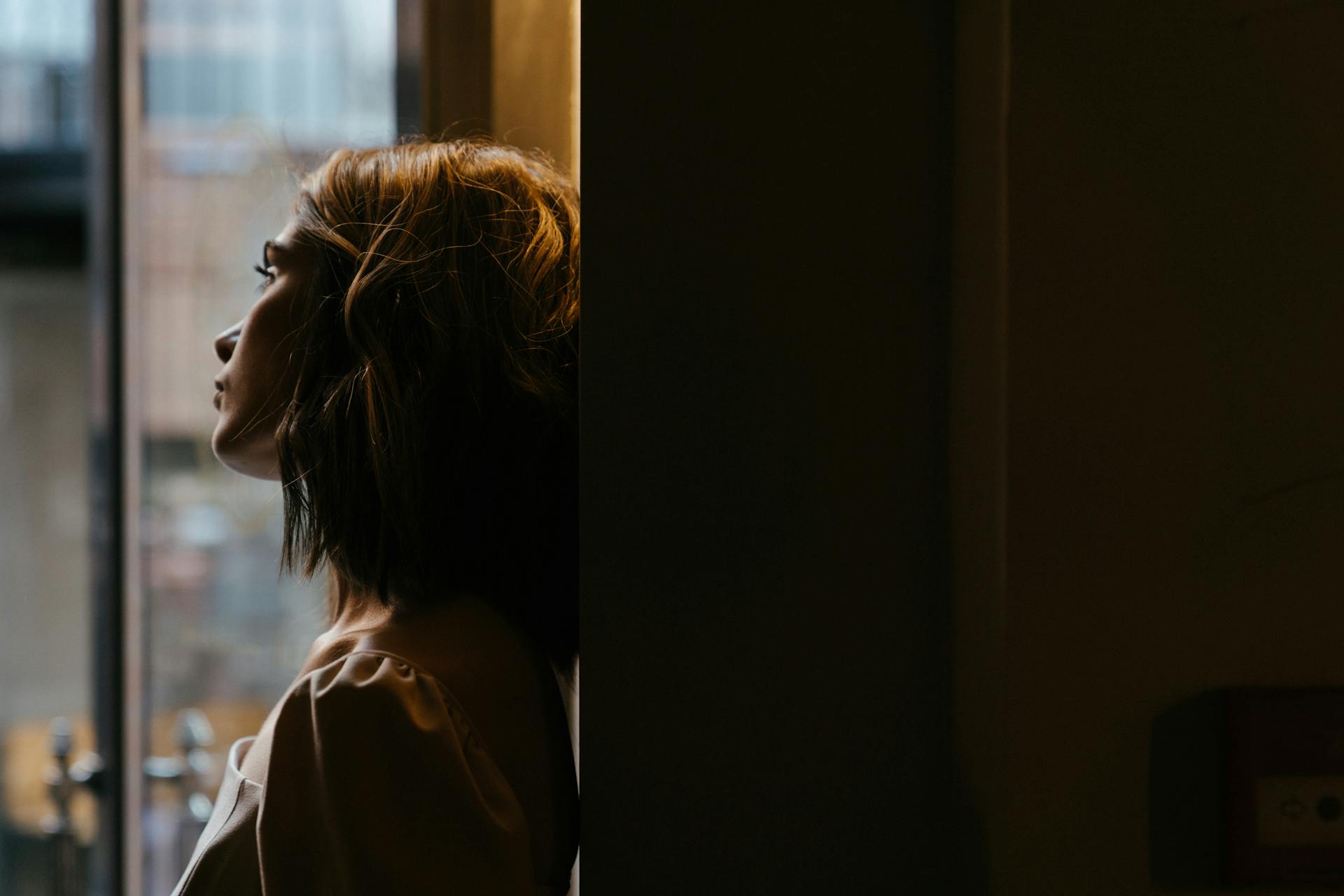 Una mujer pensativa mirando por la ventana | Fuente: Pexels