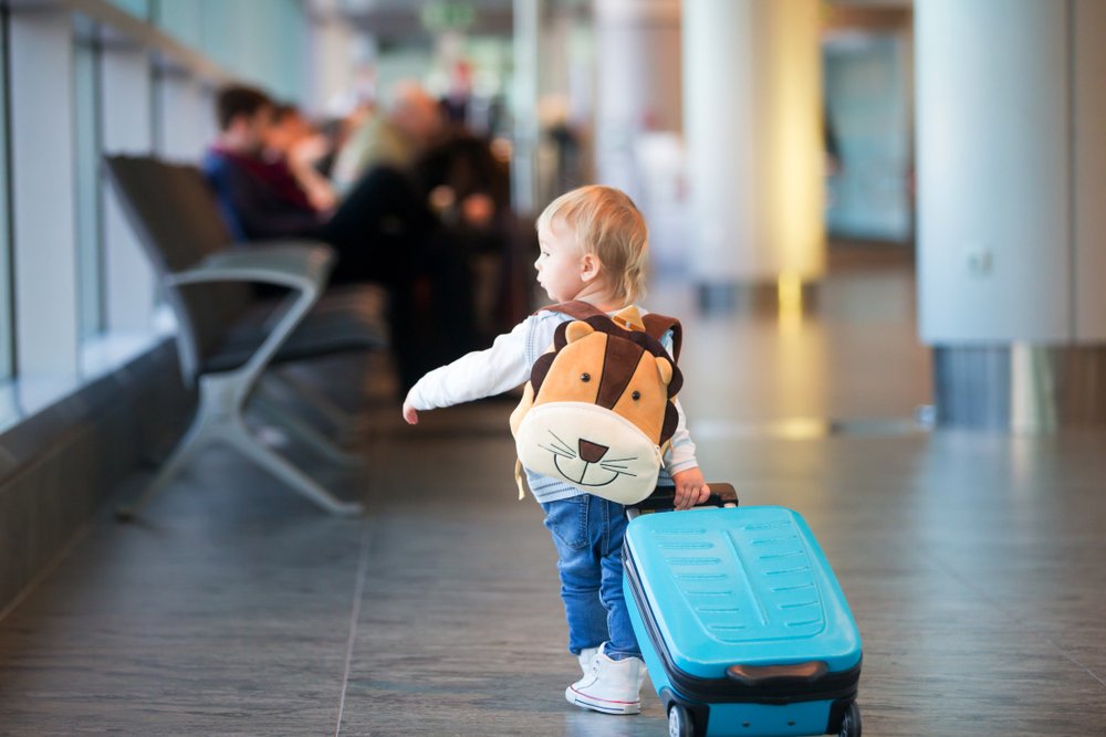 Niño caminando por un aeropuerto con su maleta. | Foto: Shutterstock.