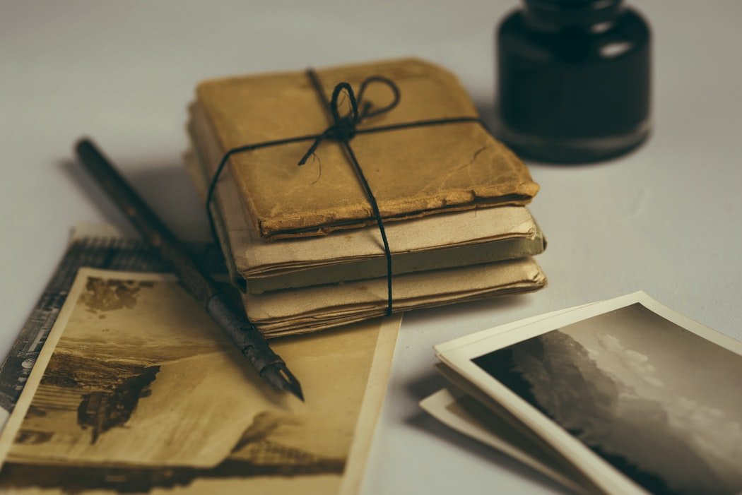 Un atado de cartas, libros viejos y una estiligráfica. | Foto: Pexels