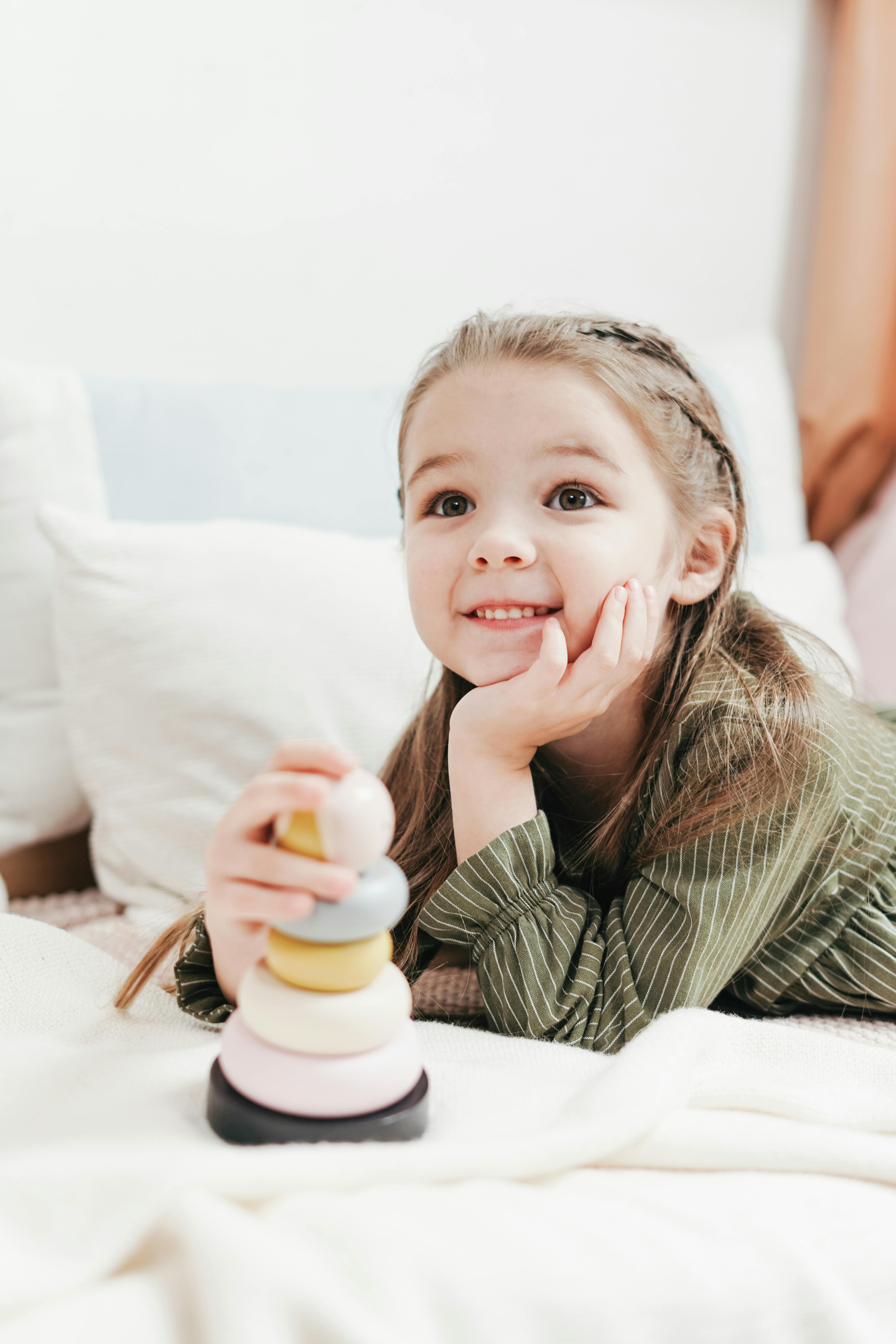 Una niña sonriendo mientras juega | Fuente: Pexels