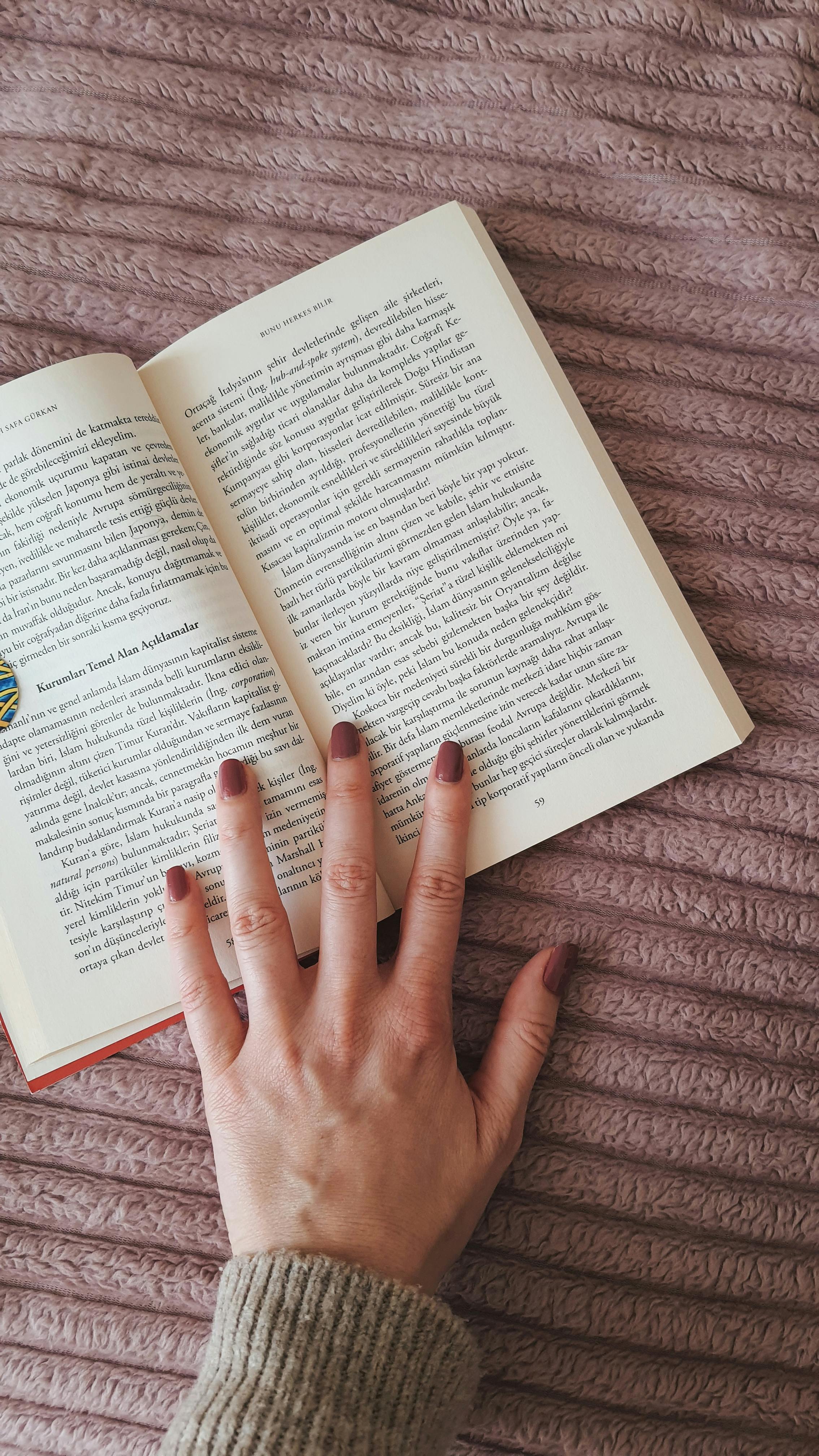 La mano de una mujer sobre un libro | Fuente: Pexels