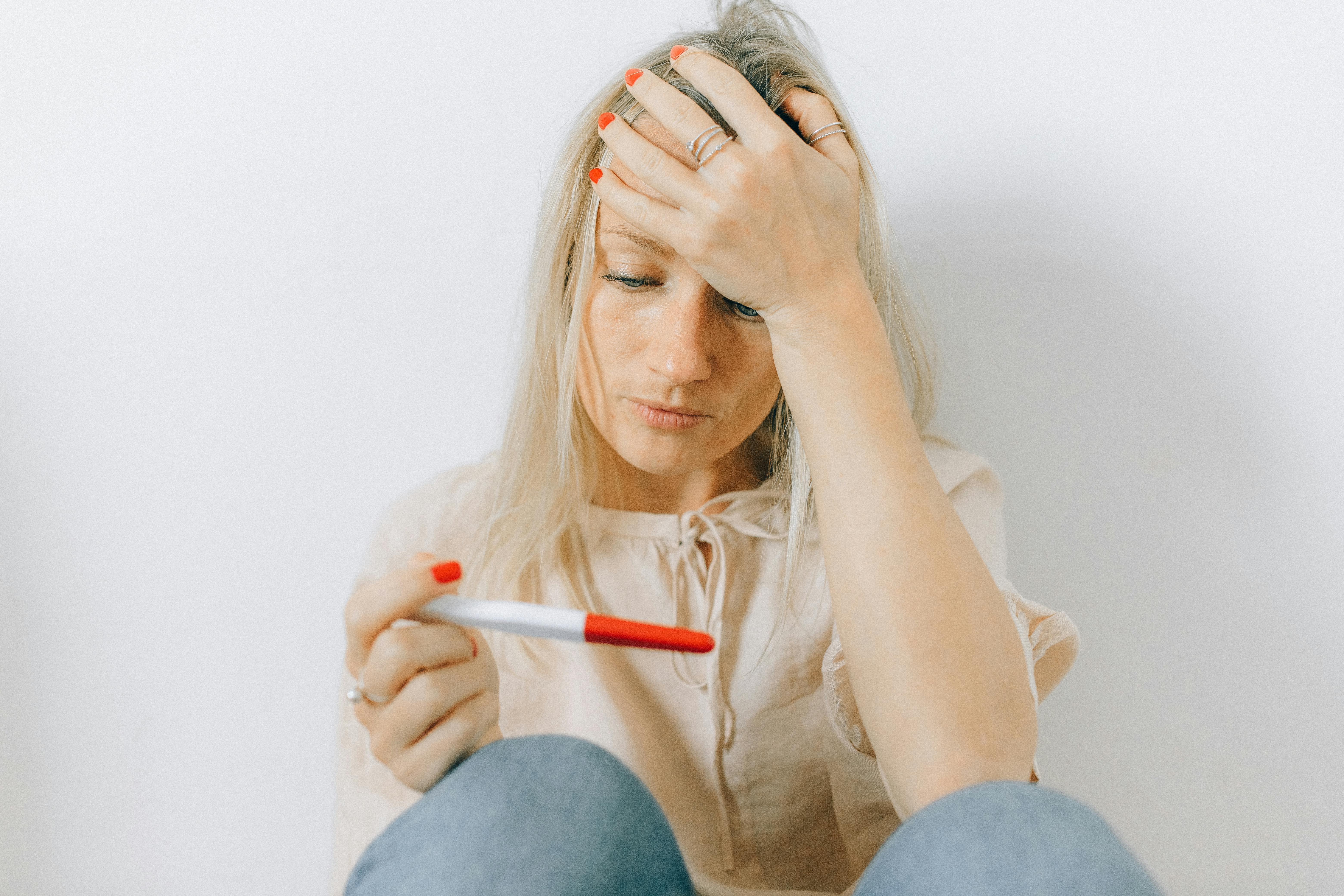 Mujer con un test de embarazo | Foto: Pexels