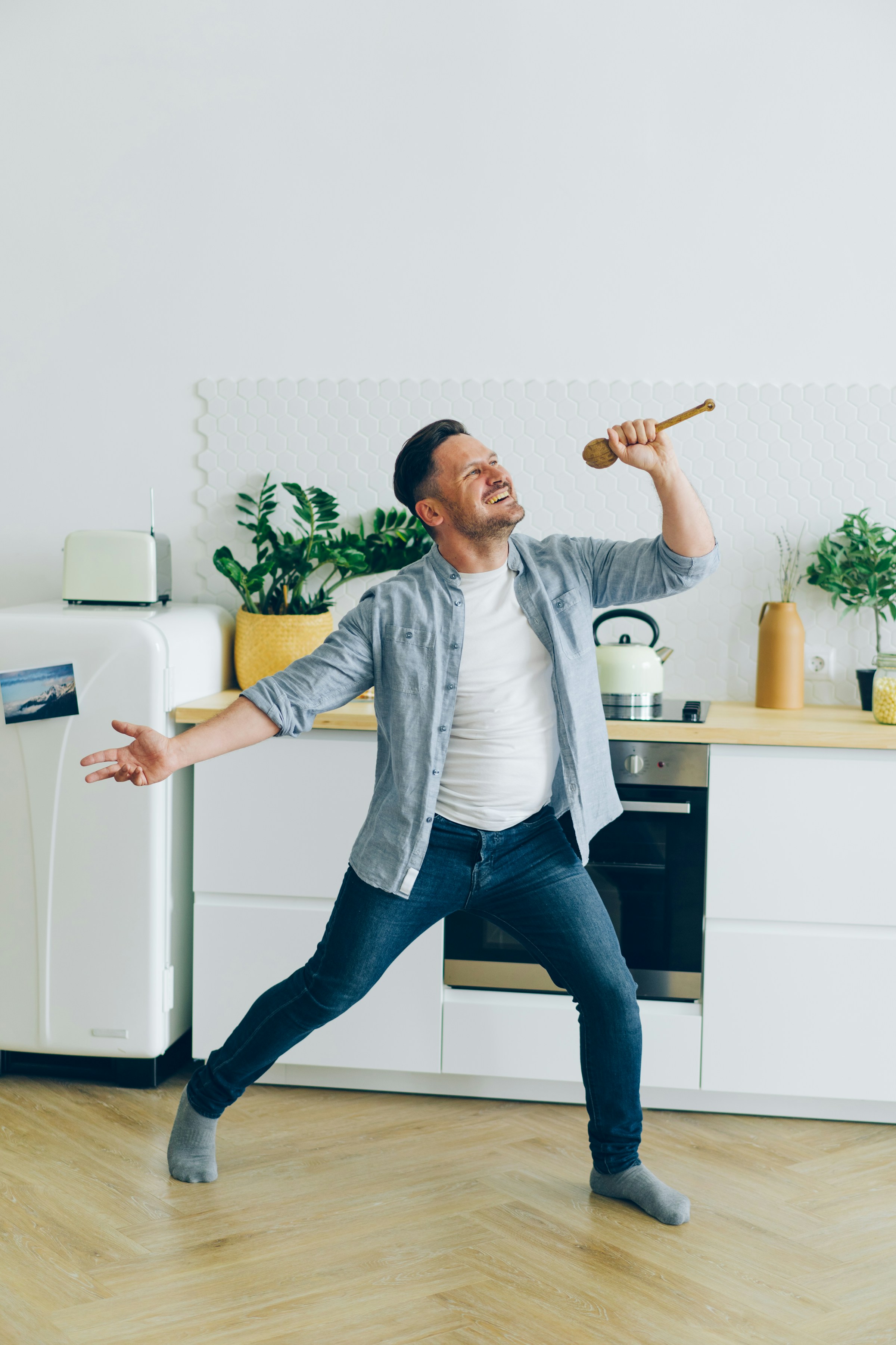 Un hombre divirtiéndose en la cocina sujetando una cuchara de madera | Fuente: Unsplash