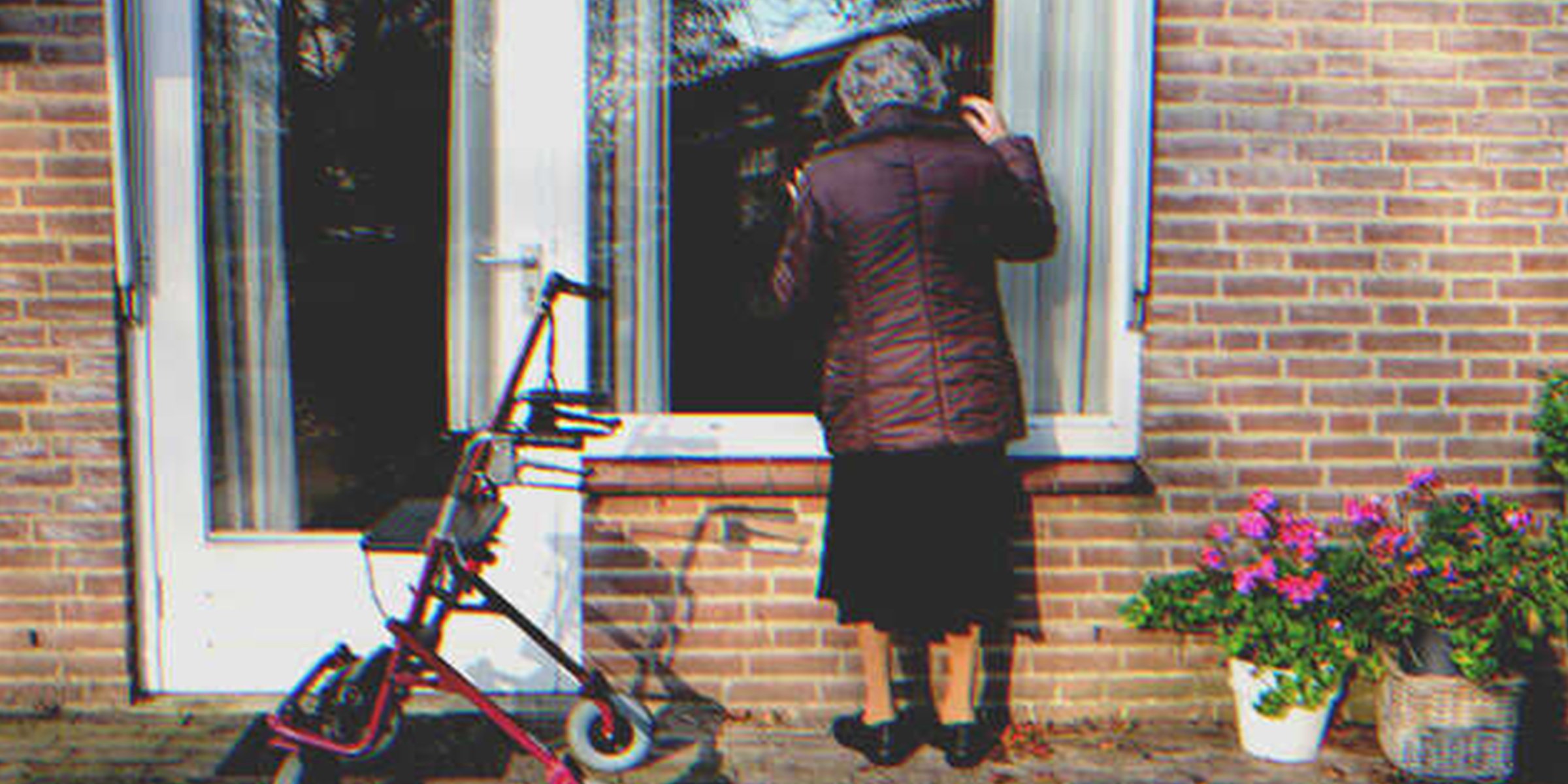 Una mujer mayor mirando por una ventana | Foto: Shutterstock