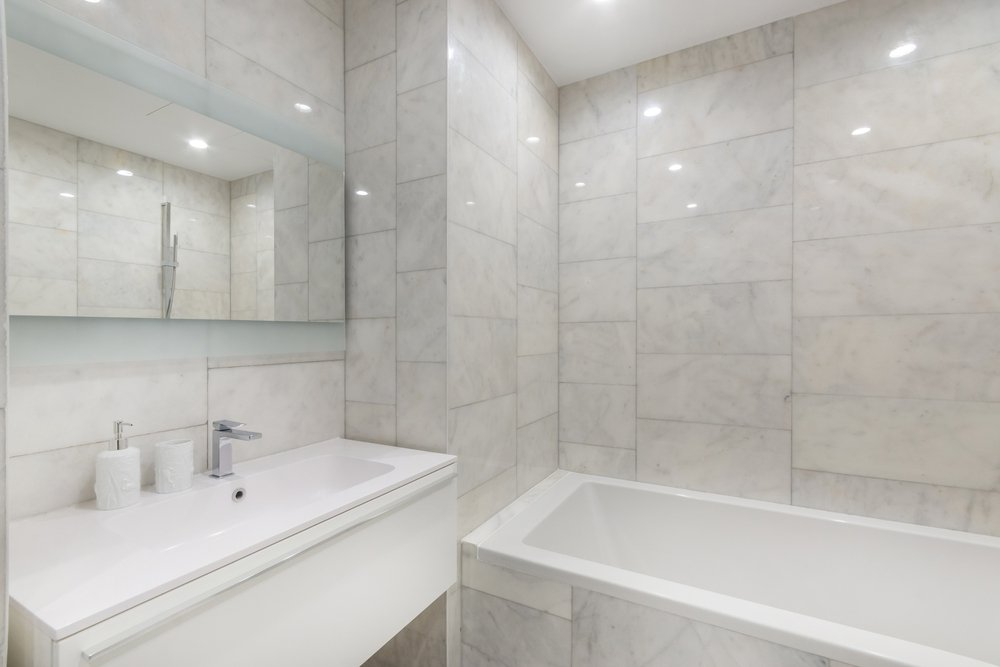 Baño con bañera, lavabo y paredes de mármol. | Foto: Shutterstock