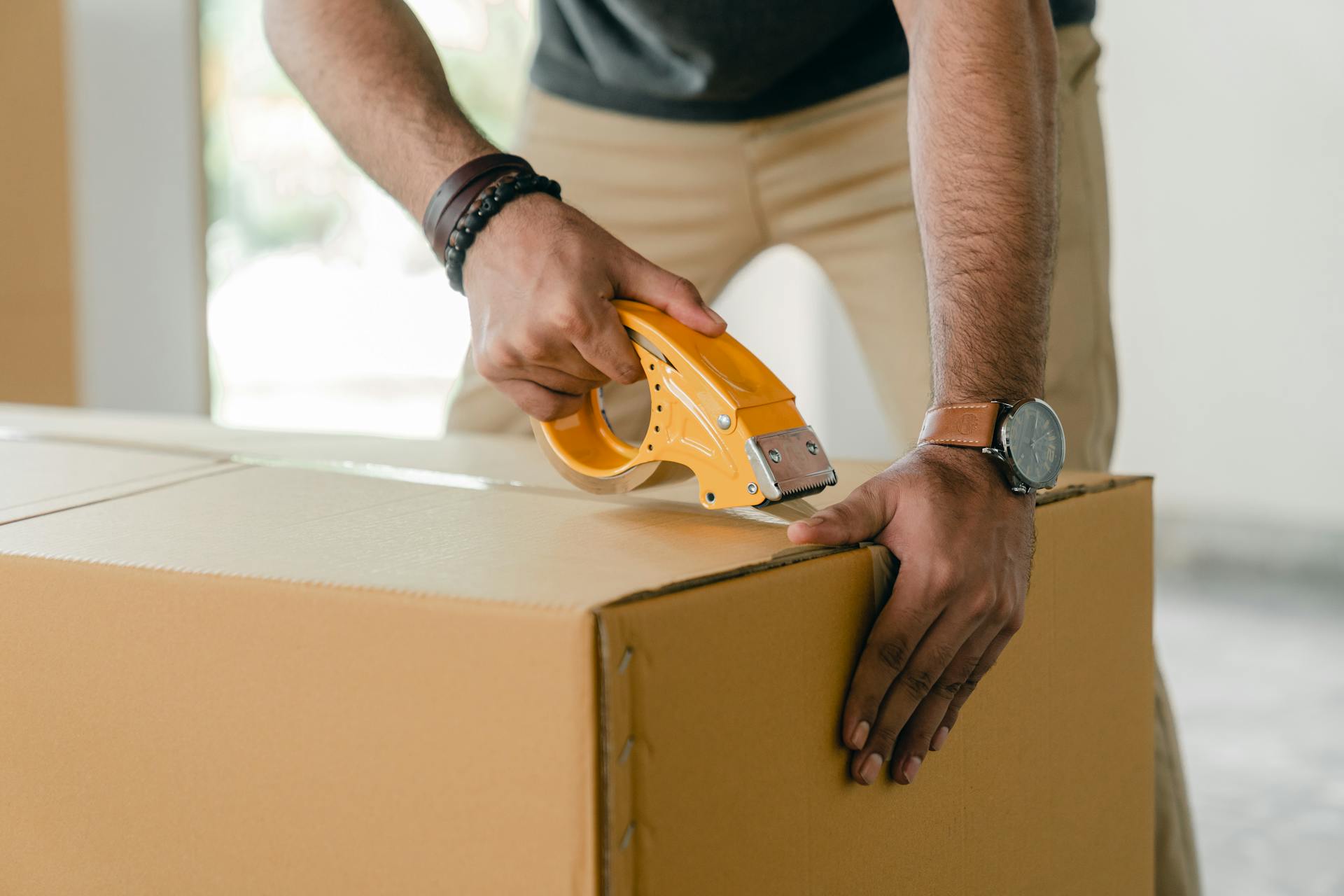 Un hombre empaquetando ropa en una caja | Fuente: Pexels
