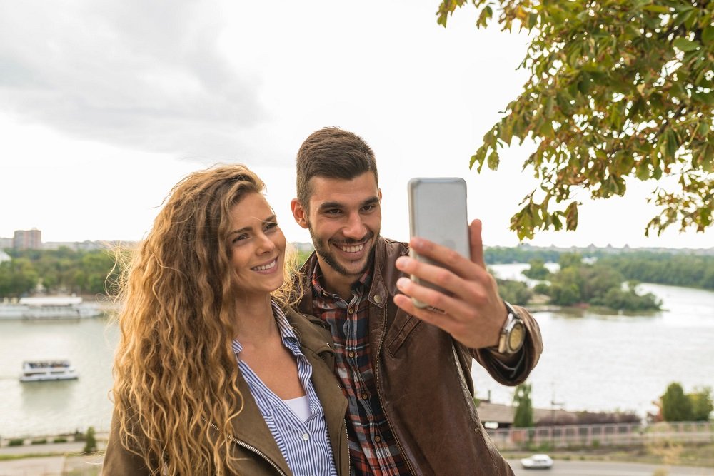 Feliz pareja tomándose una selfie.| Imagen: Pexels