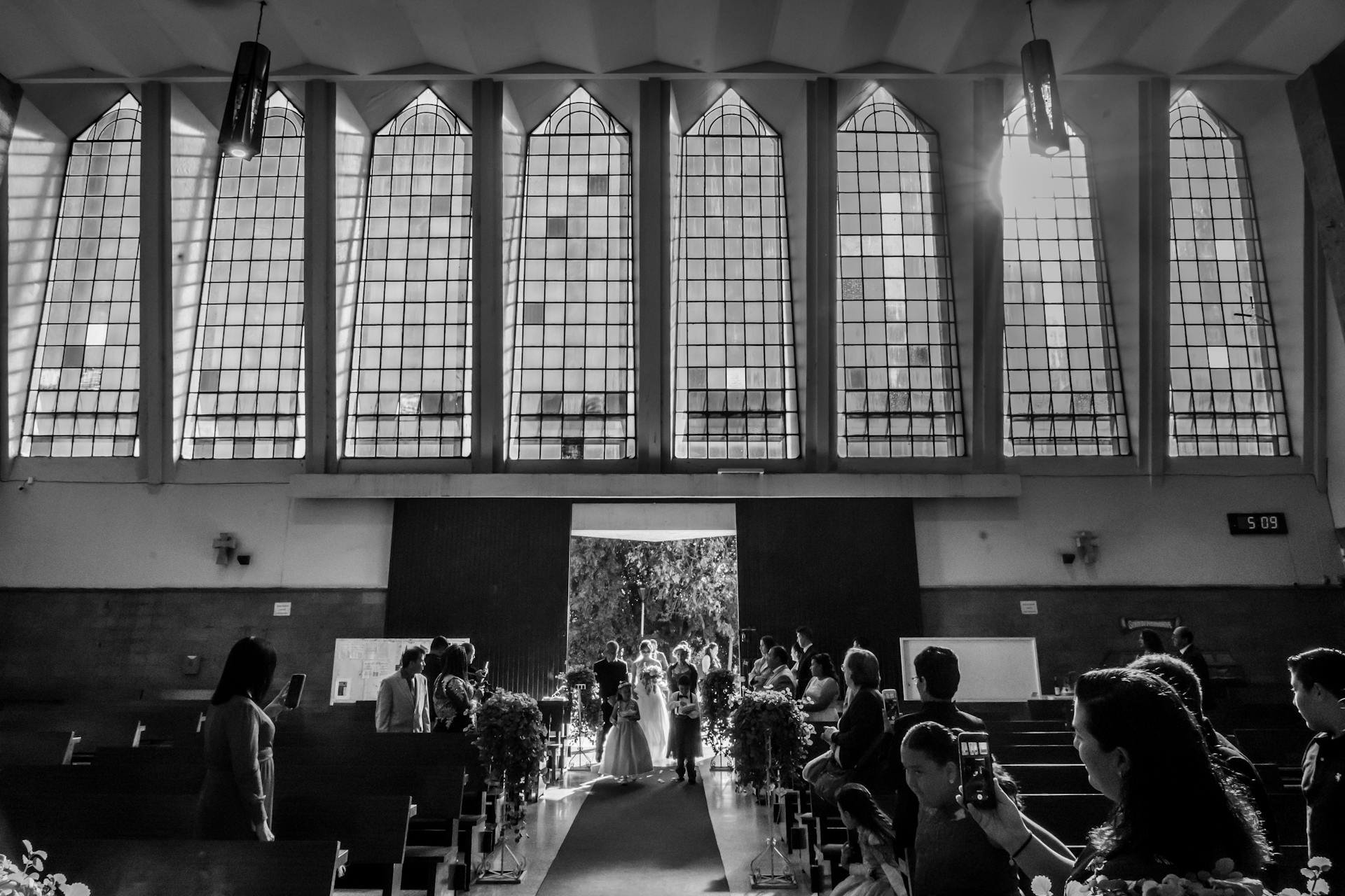 Toma en escala de grises de los invitados a una ceremonia nupcial | Fuente: Pexels