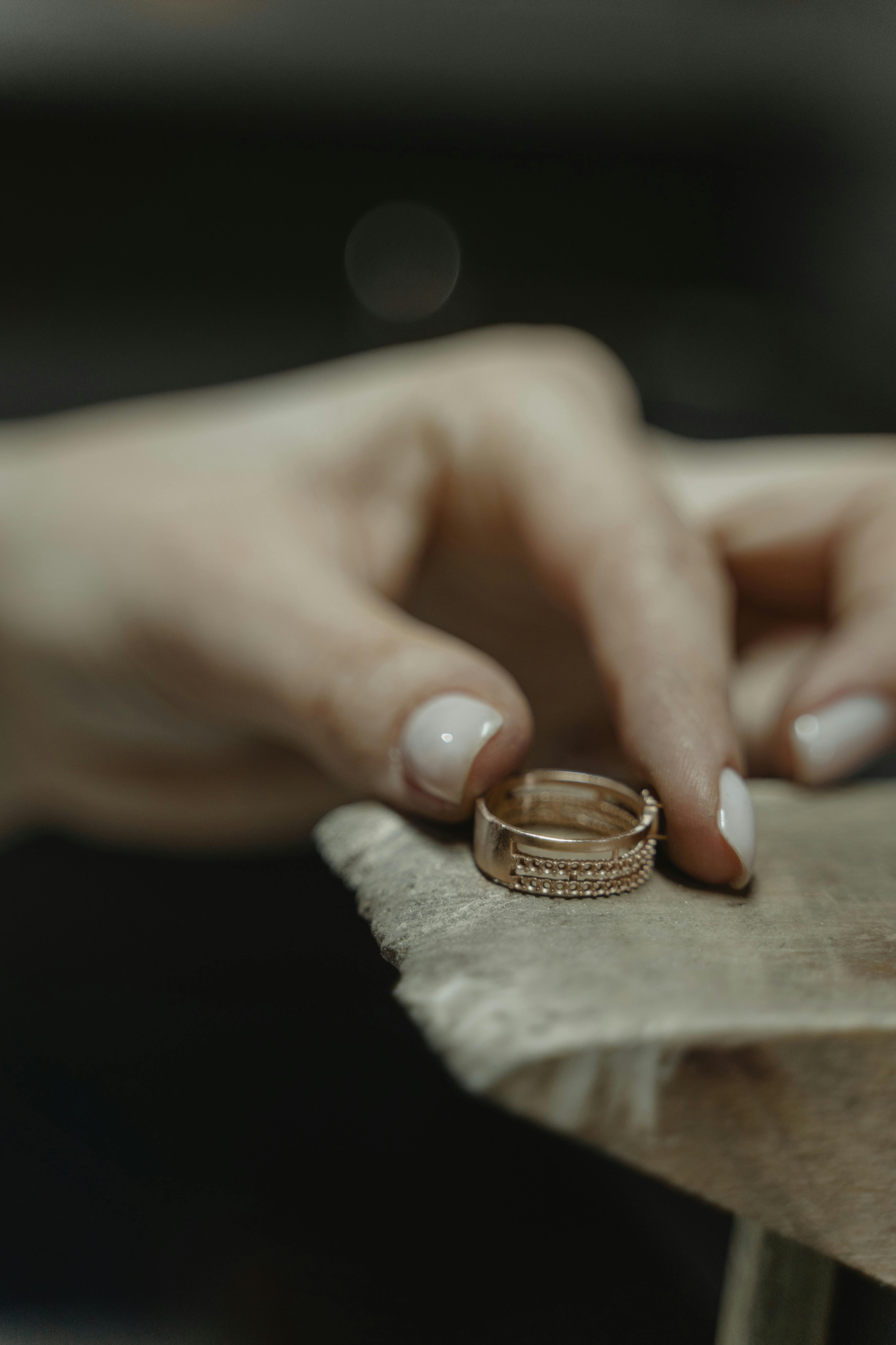 Mano de mujer sujetando un anillo | Fuente: Pexels