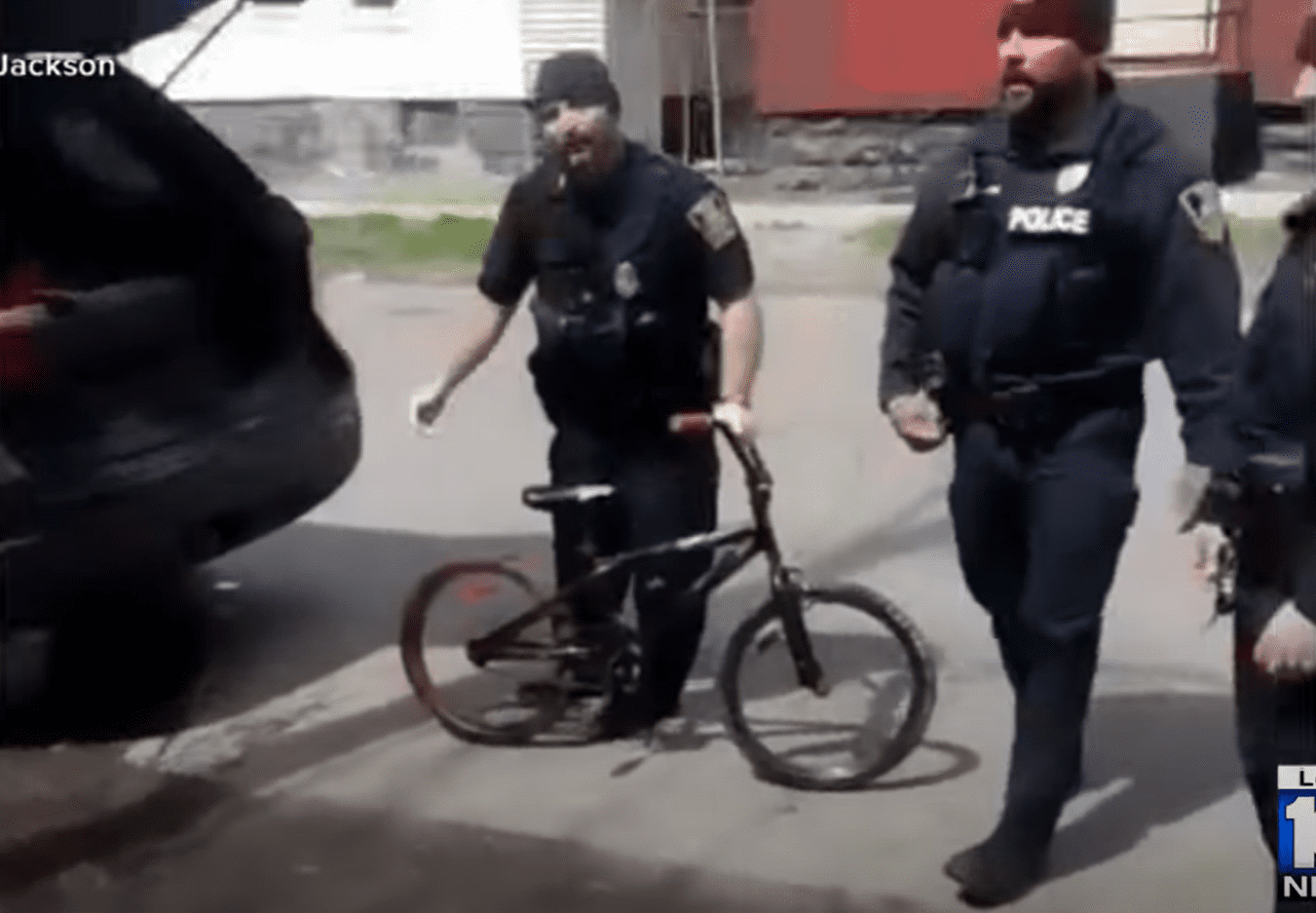 Agentes de policía de pie junto a la bicicleta del niño. | Foto: Youtube.com/WPLG Local 10