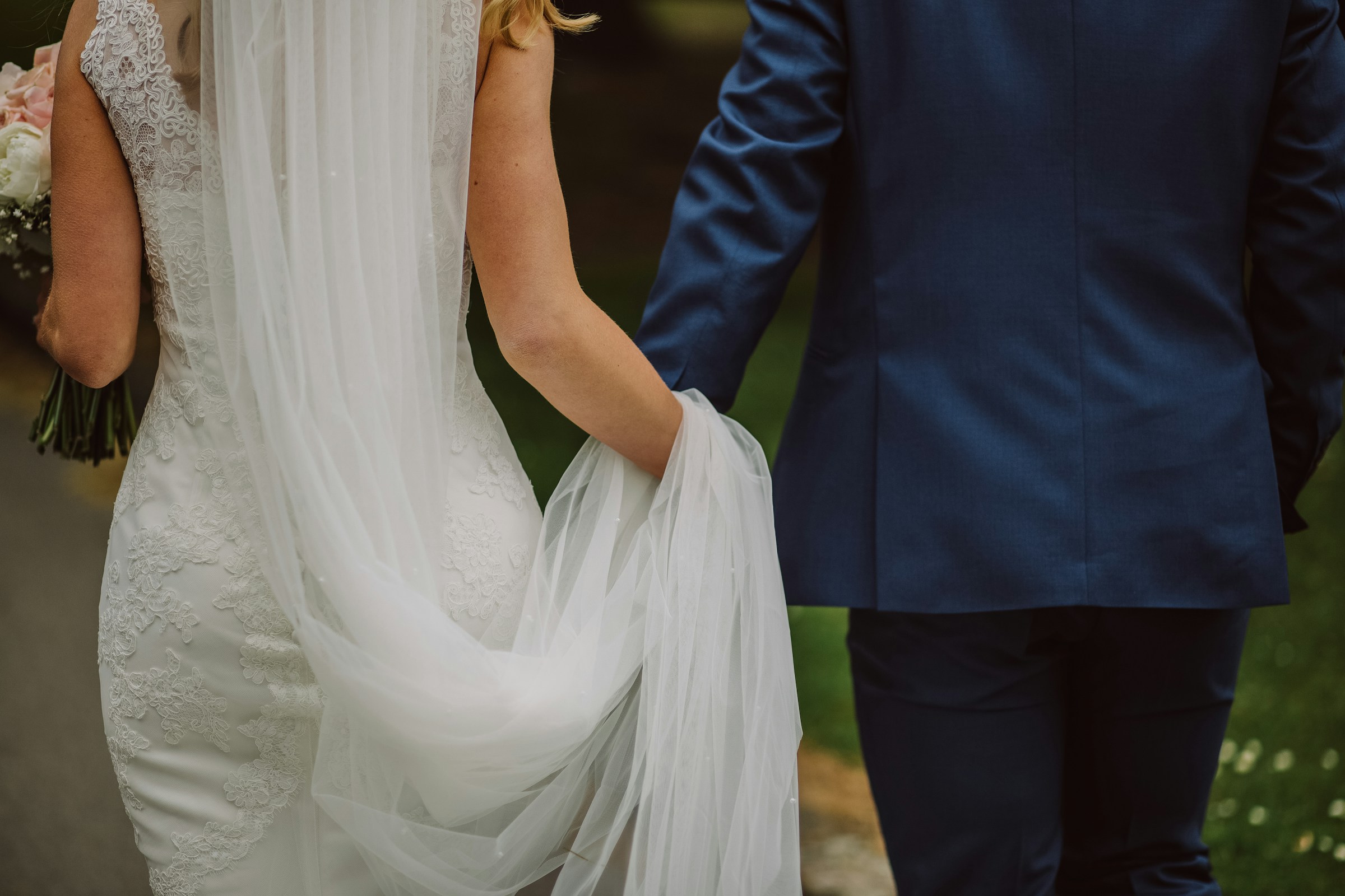 Una pareja de recién casados cogidos de la mano y caminando juntos | Fuente: Unsplash