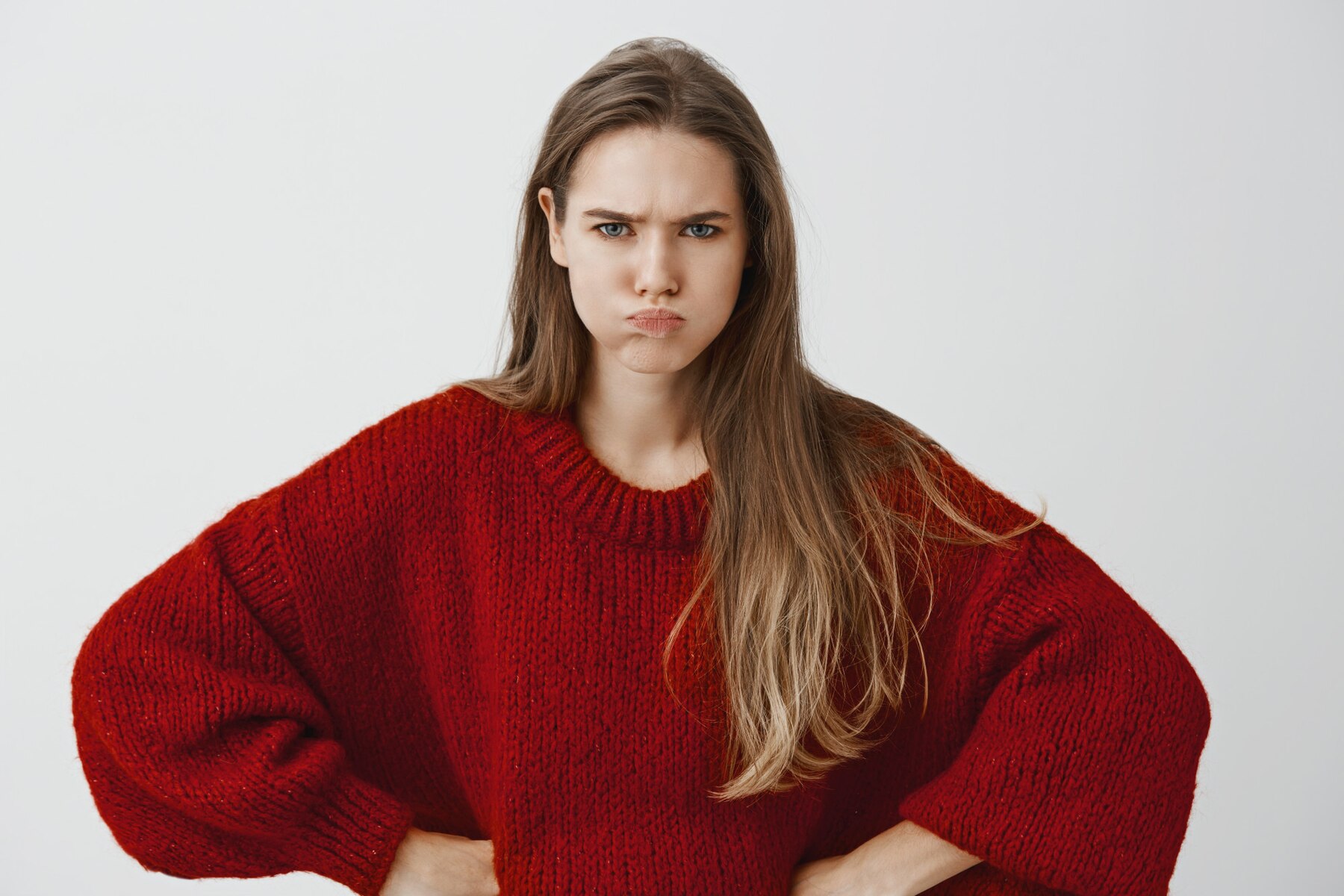 Una joven enfadada con un jersey rojo | Fuente: Freepik