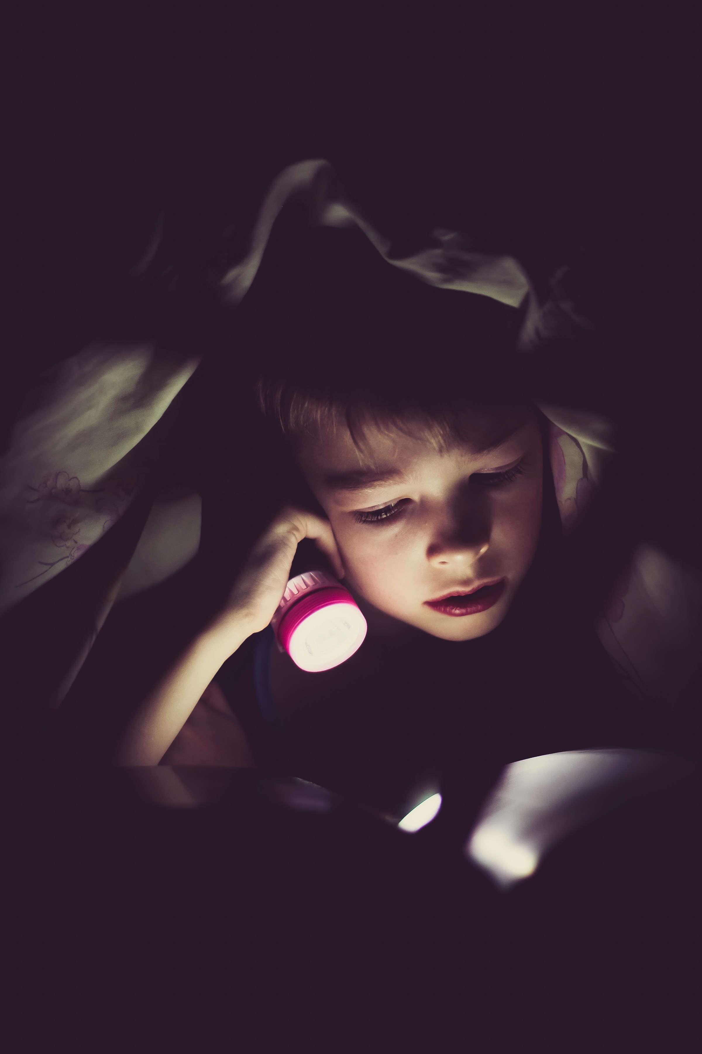 Un niño con una linterna en la mano | Foto: Unsplash