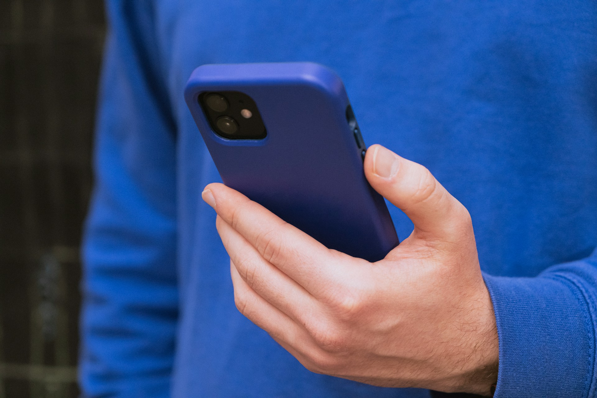 Foto recortada de un hombre sujetando su teléfono | Fuente: Unsplash