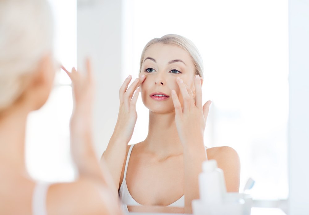 Mujer aplicando producto hidratante en el contorno de sus ojos. | Foto: Shutterstock
