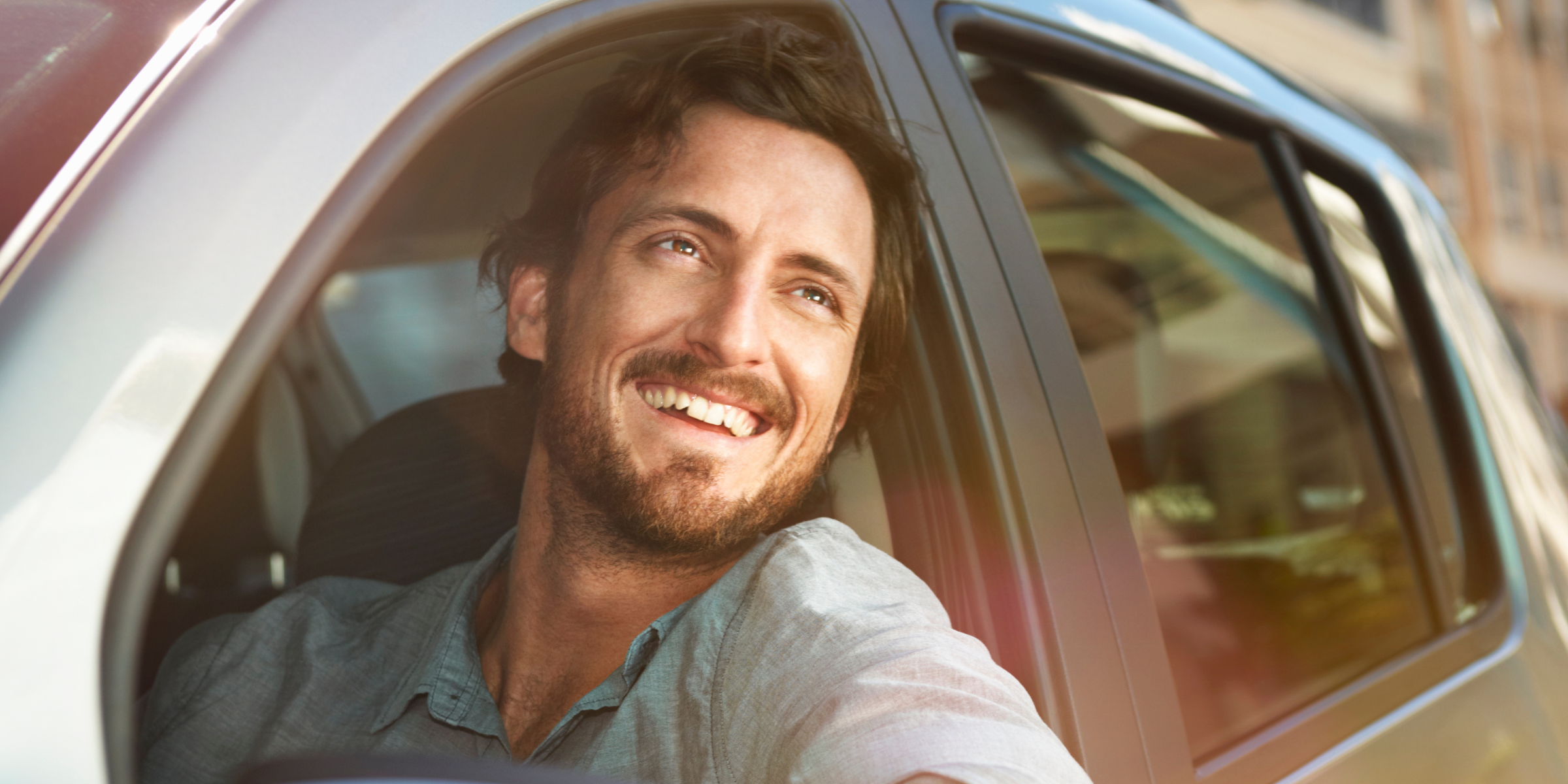 Un uomo che sorride dal finestrino di un’auto | Fonte: Getty Images