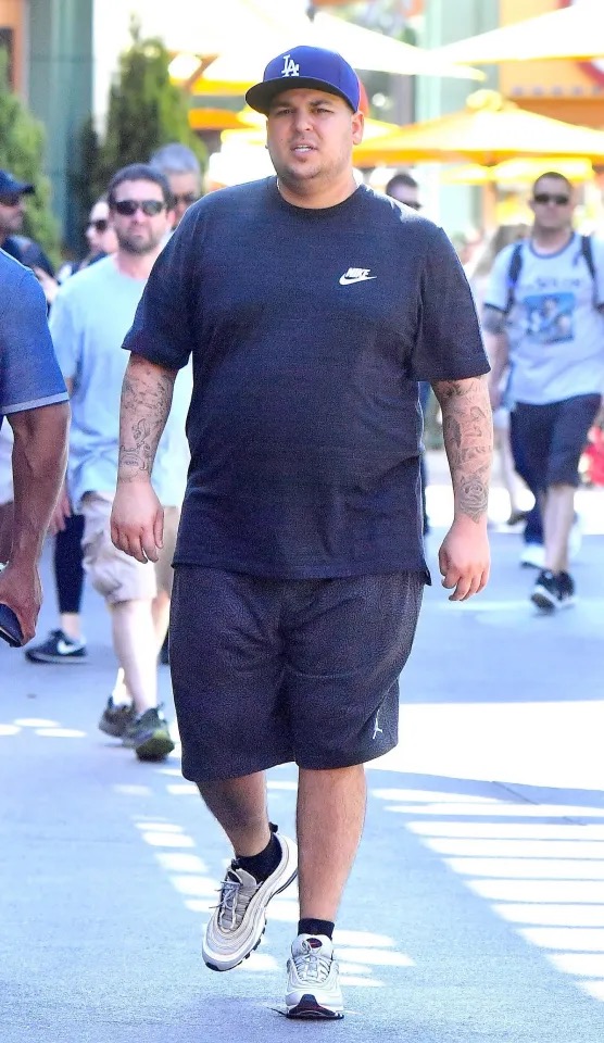 Rob Kardashian fue fotografiado paseando al aire libre con una camiseta negra de Nike, pantalones cortos y una gorra de béisbol de Los Ángeles. La imagen muestra su figura más rellenita en una época en la que se mostraba cada vez más abierto sobre sus problemas con el peso y la confianza en su cuerpo. | Fuente: The Mega Agency.