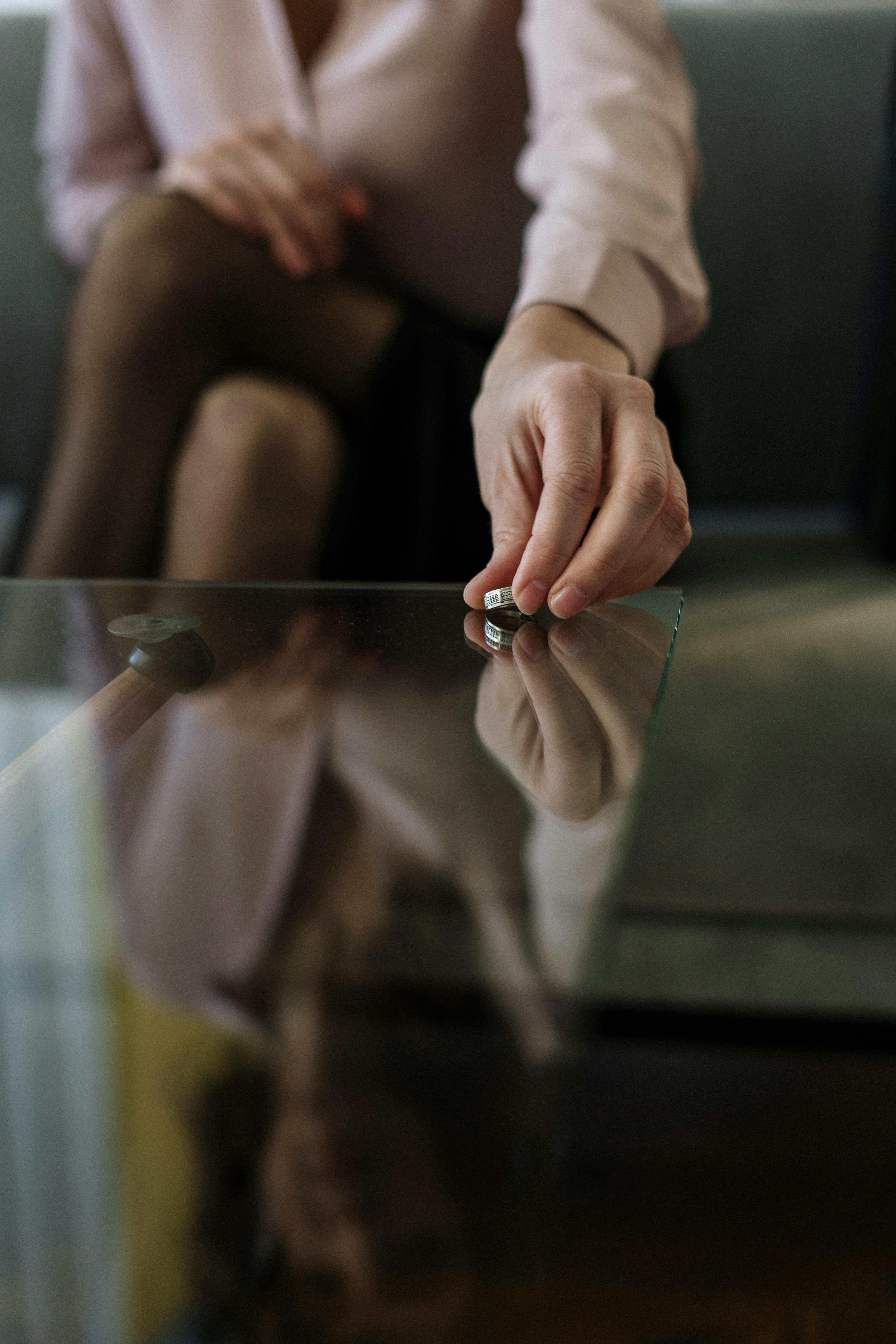 Mujer dejando el anillo sobre la mesa | Fuente: Pexels