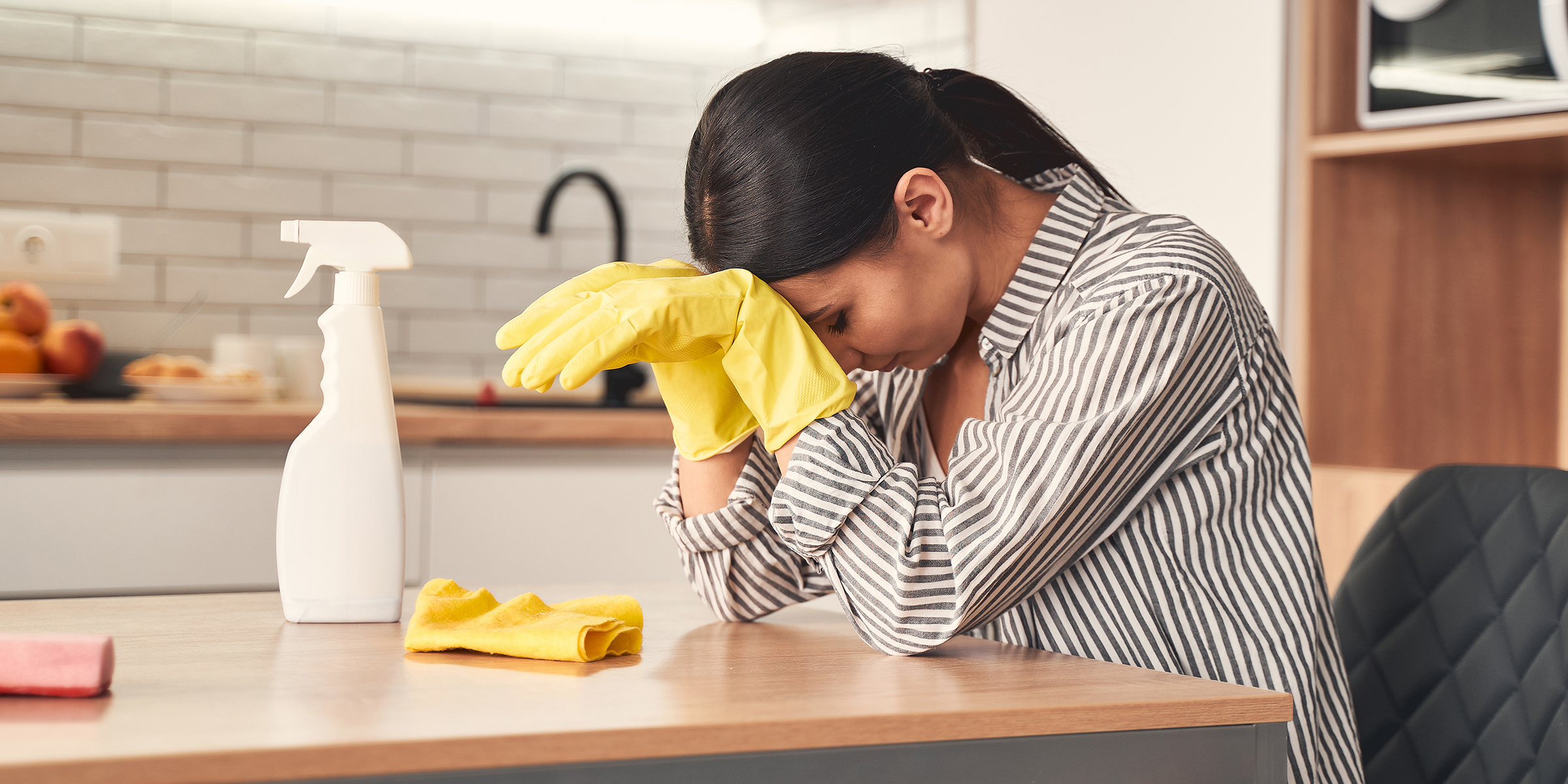 Una mujer sentada en la encimera de la cocina | Fuente: Shutterstock