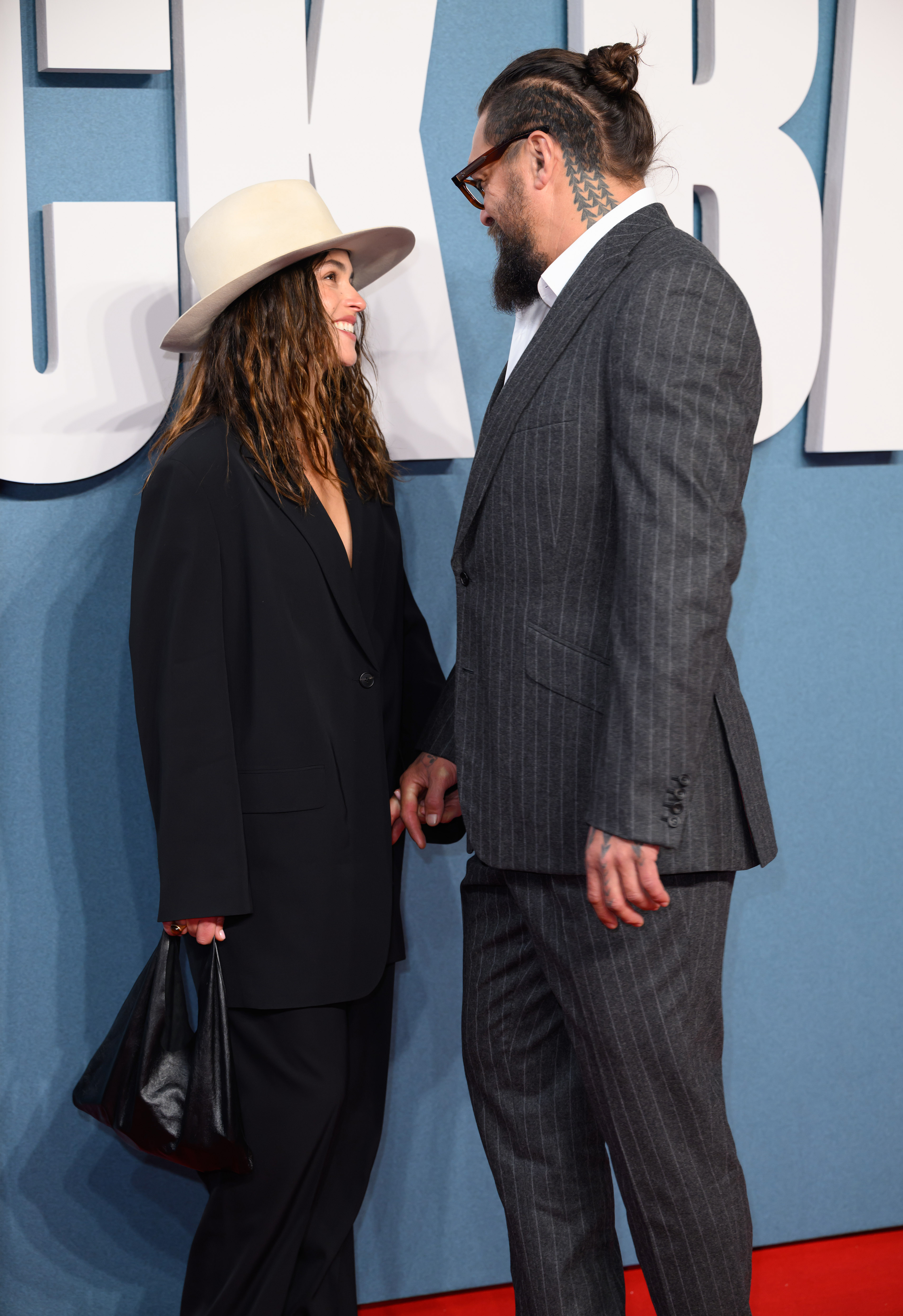 Adria Arjona y Jason Momoa intercambiando sonrisas en el evento. | Fuente: Getty Images