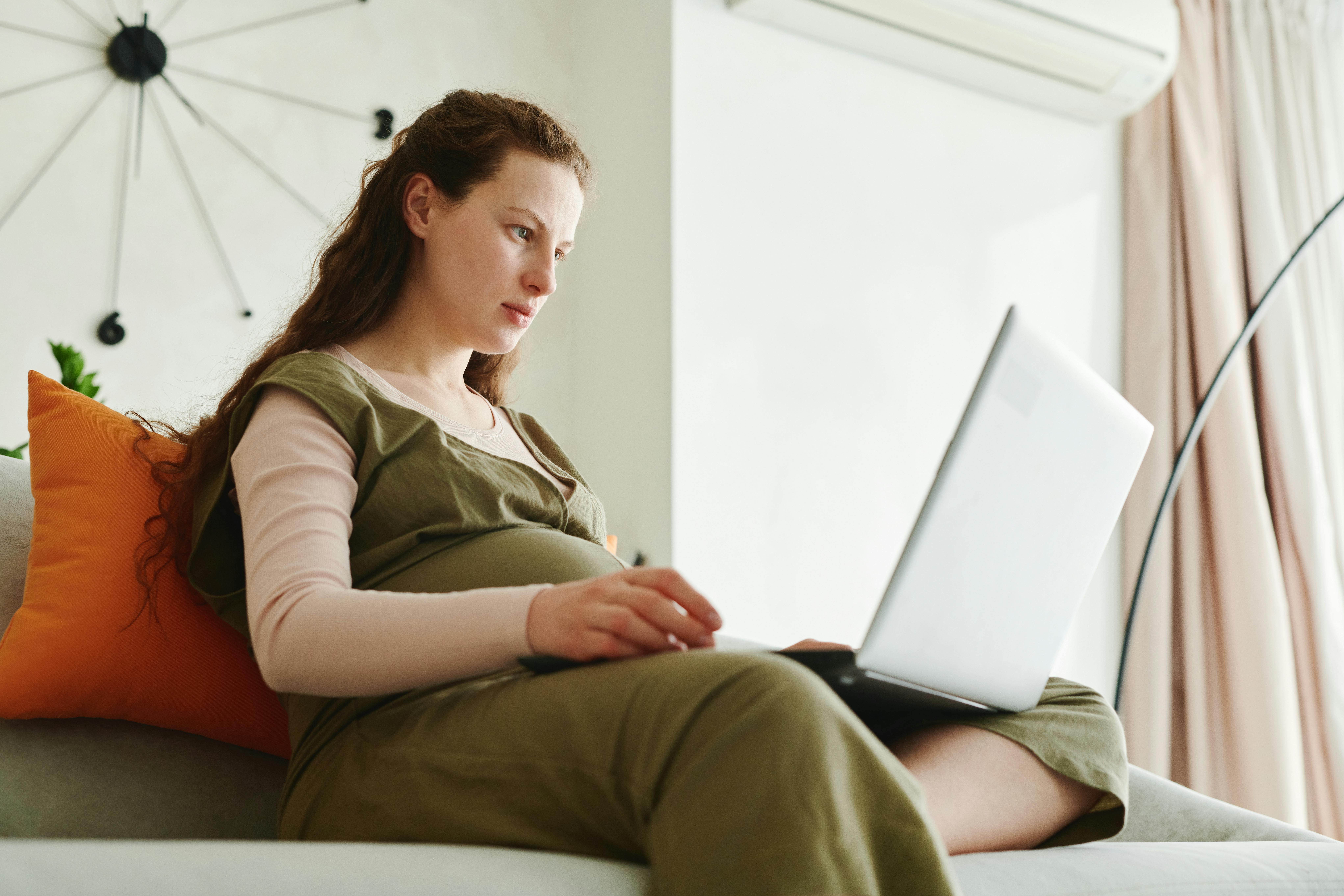 Una mujer embarazada trabajando con un portátil | Foto: Pexels