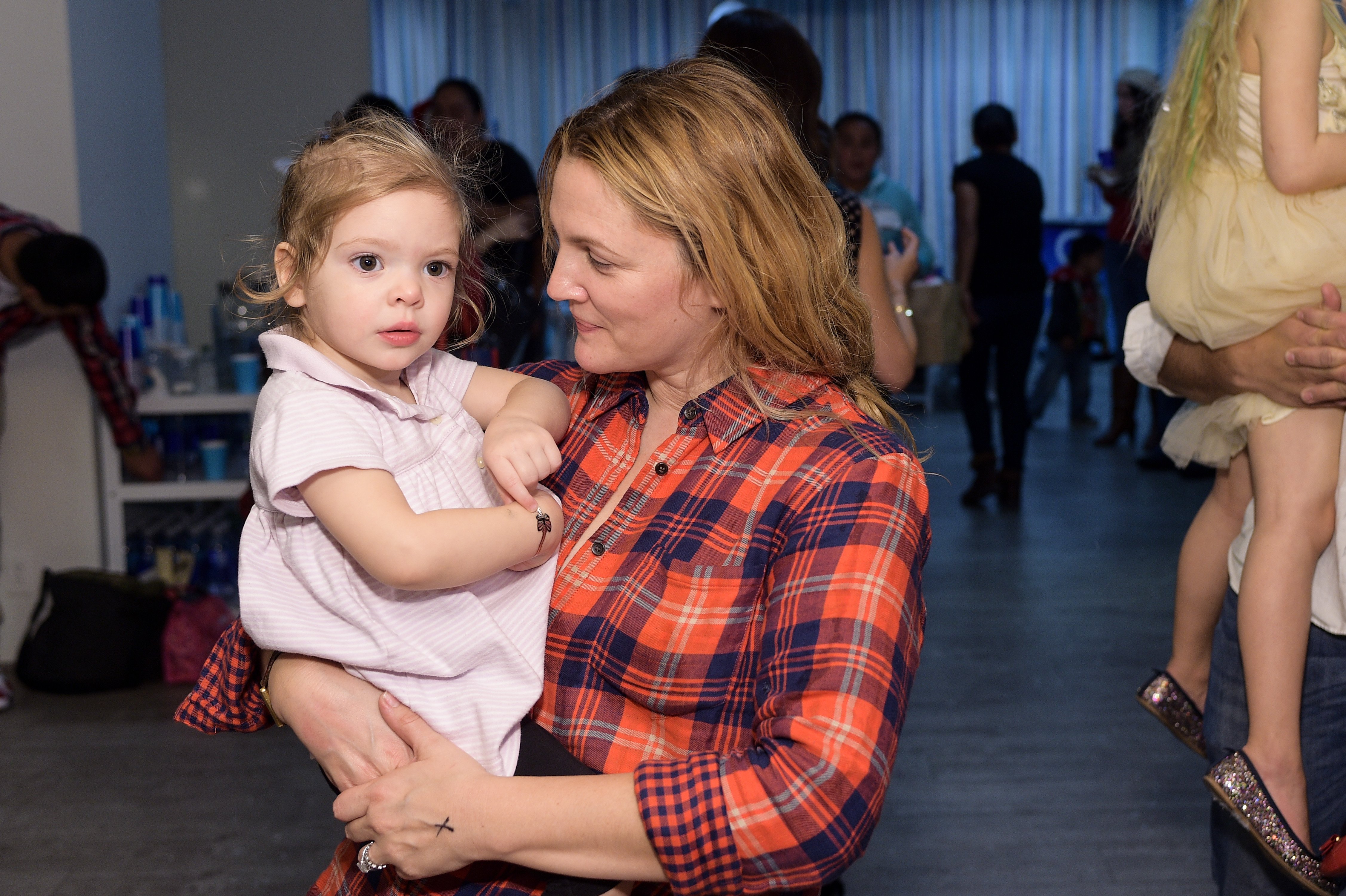 Drew Barrymore y su hija en la fiesta navideña Baby2Baby presentada por The Honest Company, el 13 de diciembre de 2014 en Los Ángeles, California. | Foto: Getty Images