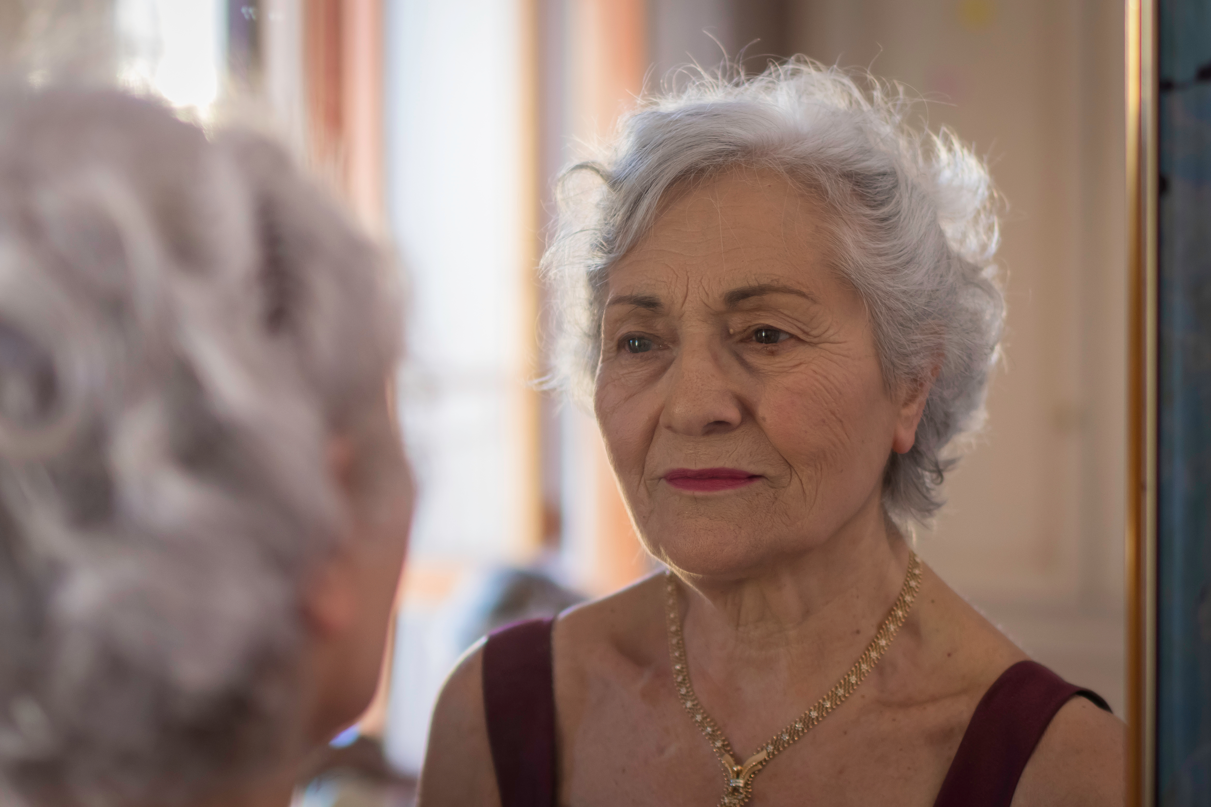 Una anciana mirándose al espejo | Foto: Shutterstock