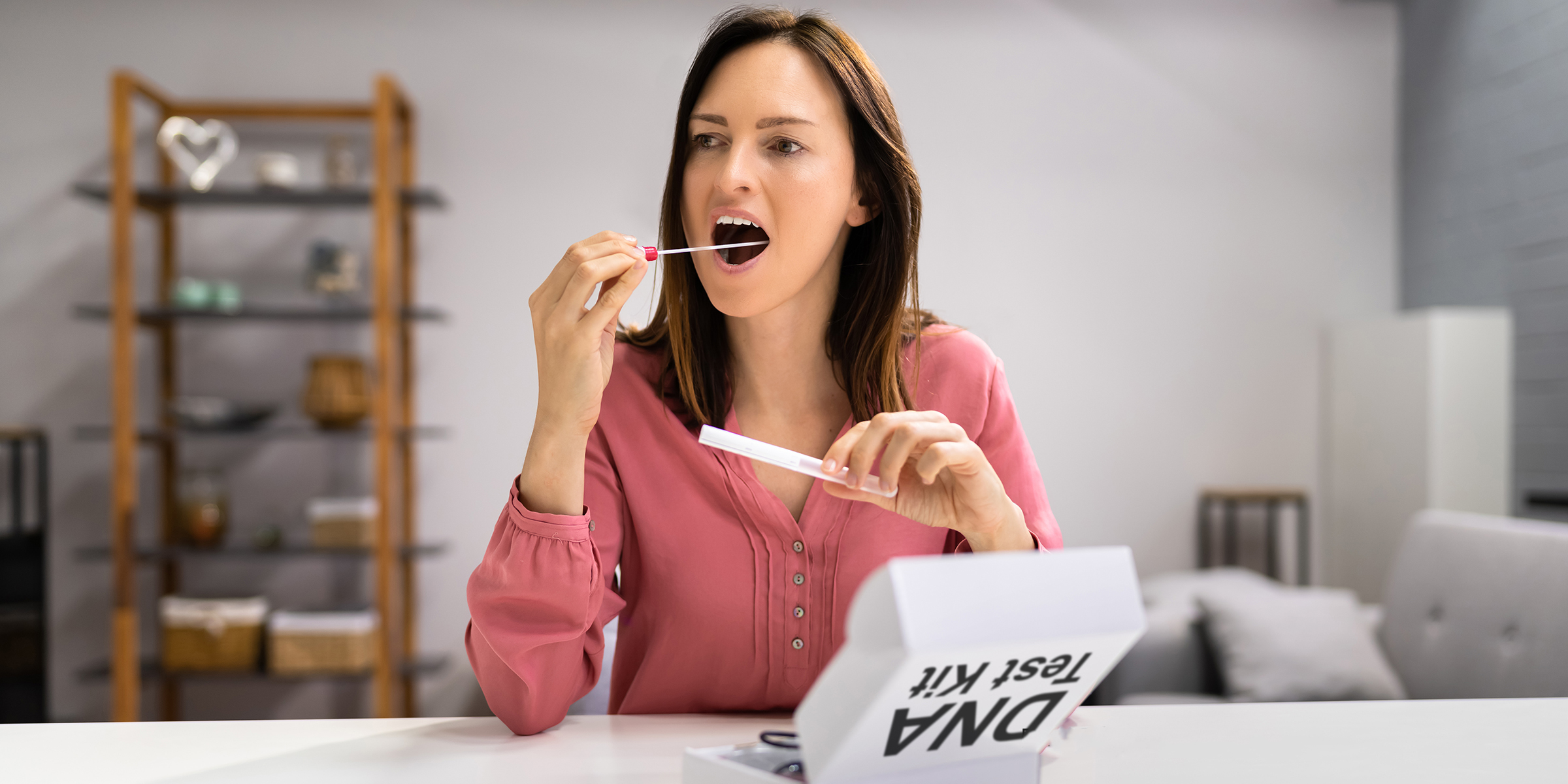 Una mujer se frota el interior de la boca para una prueba de ADN | Fuente: Shutterstock