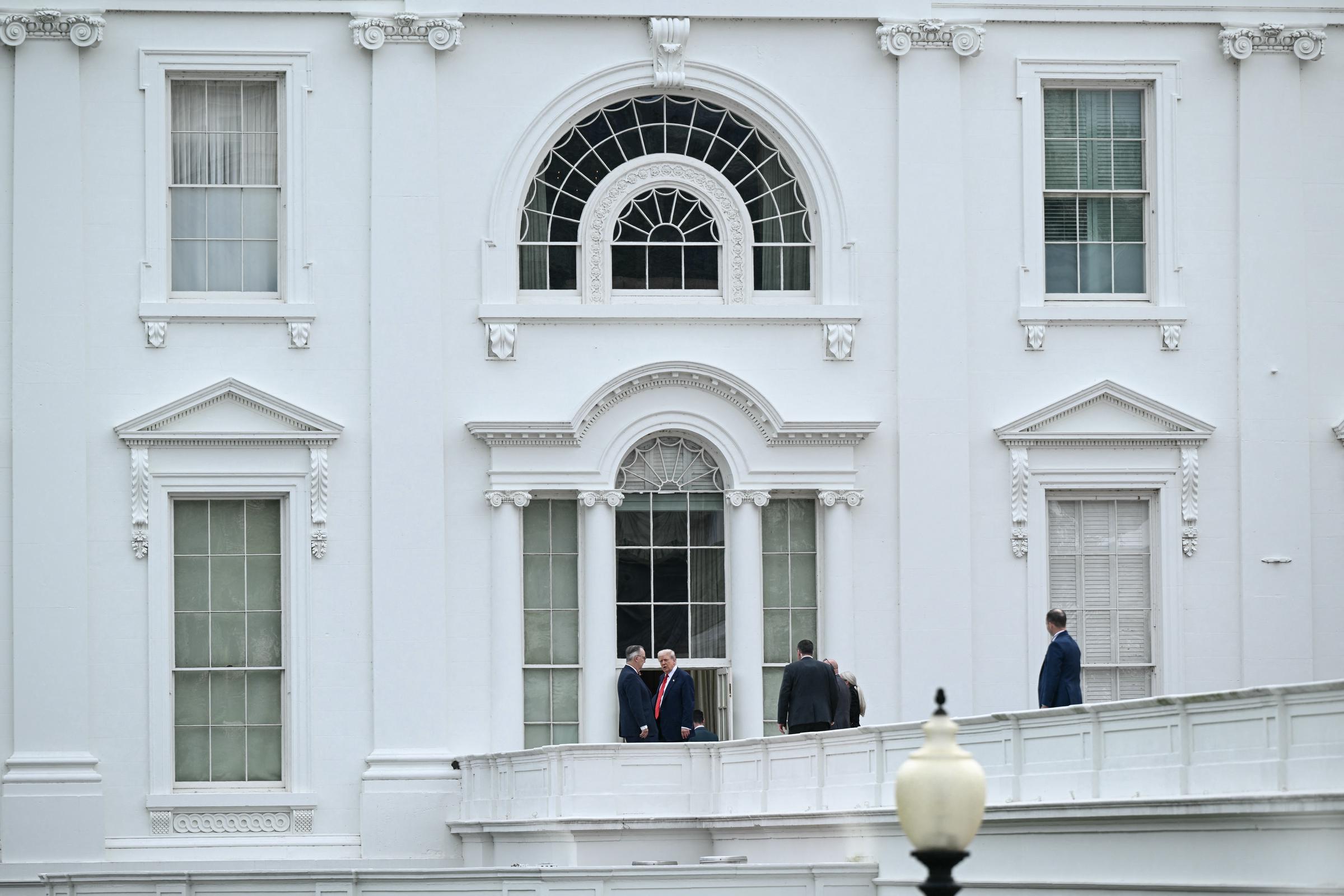 El presidente Donald Trump observa los terrenos de la Casa Blanca desde el techo del ala oeste en Washington, D. C., el 5 de agosto de 2025, mientras el personal de seguridad lo acompaña durante lo que pareció ser una inspección improvisada.