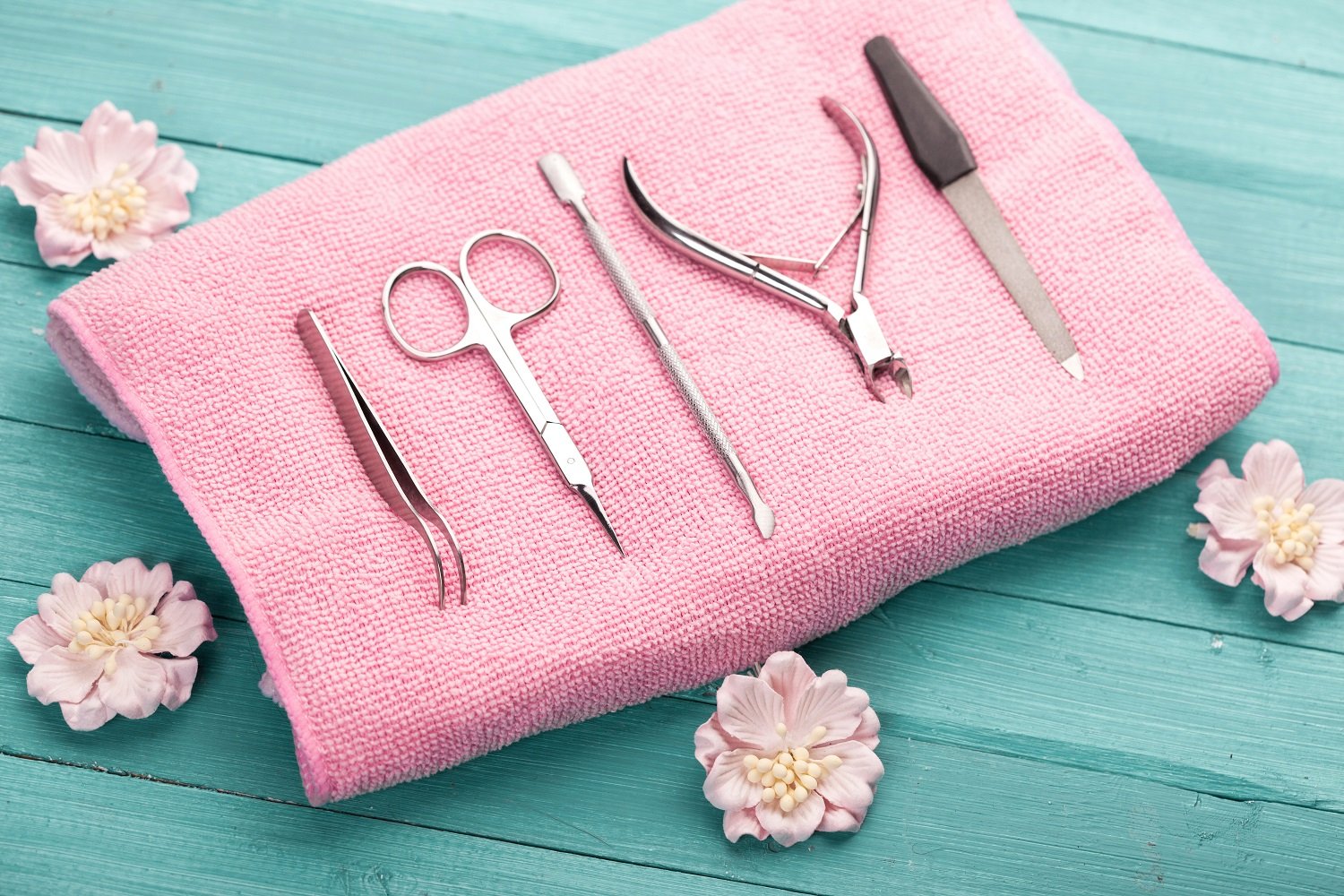Set de herramientas para manicura sobre una toalla de color rosa. | Foto: Shutterstock