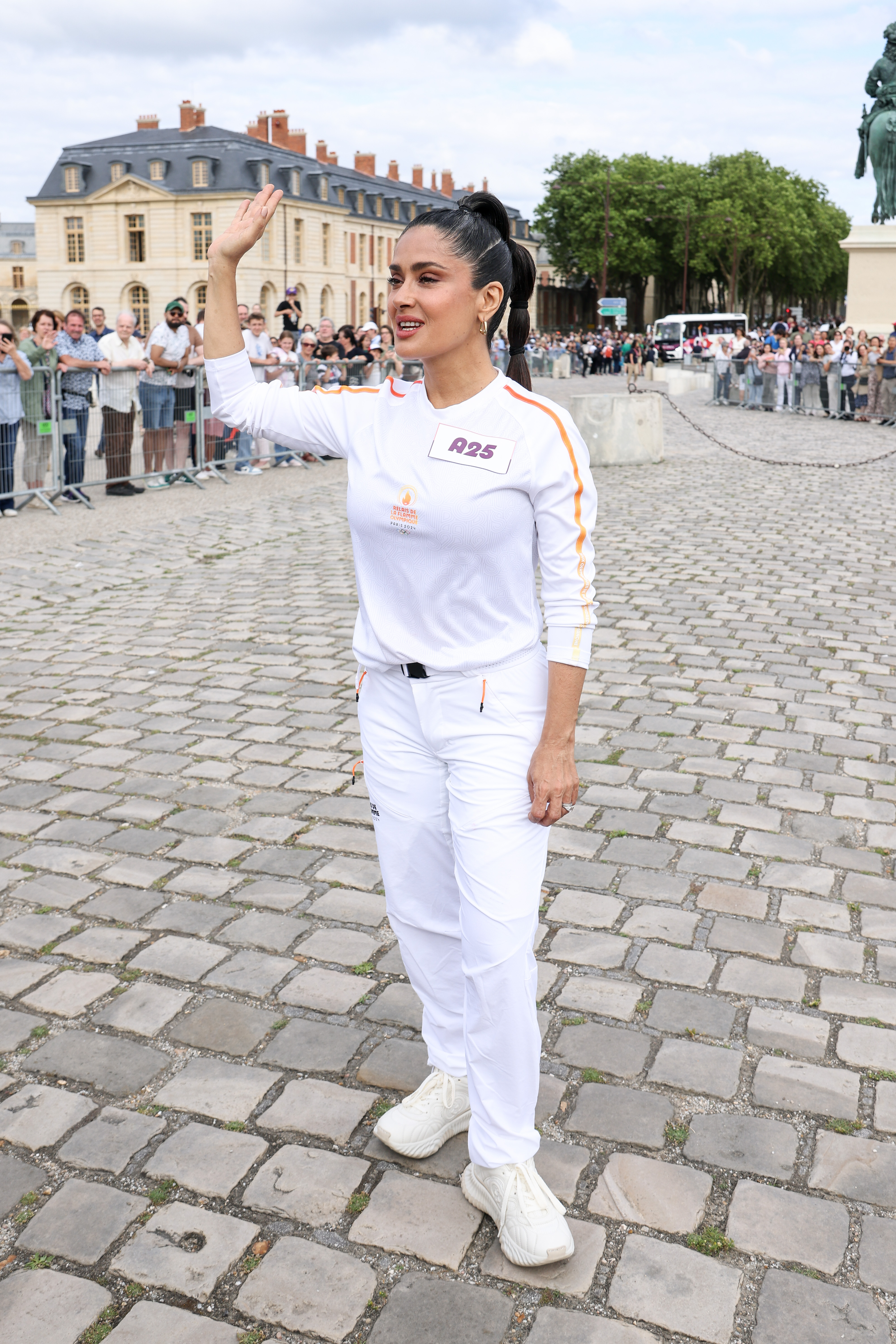 Salma Hayek corre durante el relevo de la antorcha de los Juegos Olímpicos de París en Versalles, Francia, el 23 de julio de 2024 | Fuente: Getty Images