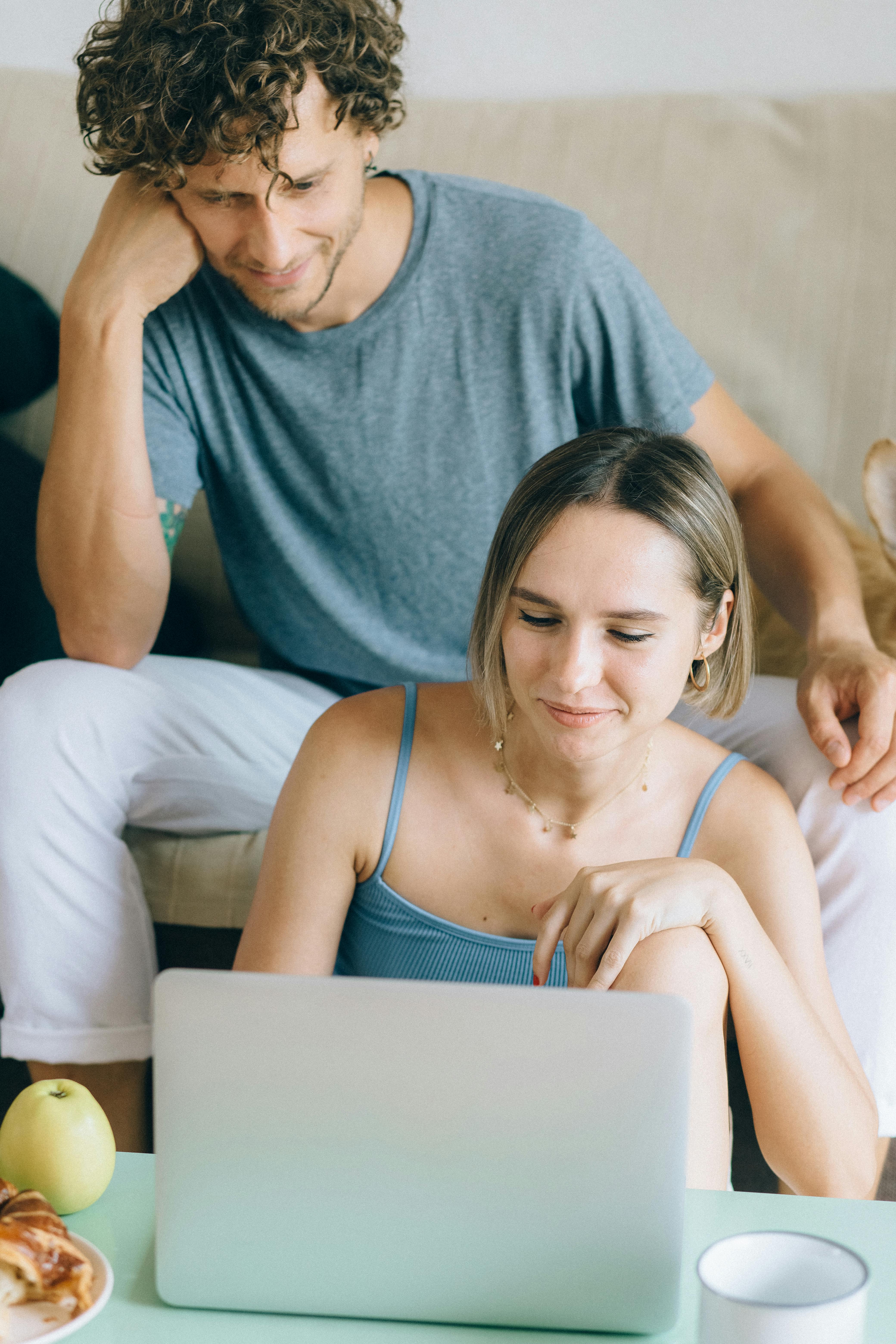 Una pareja en casa mirando un portátil | Fuente: Pexels