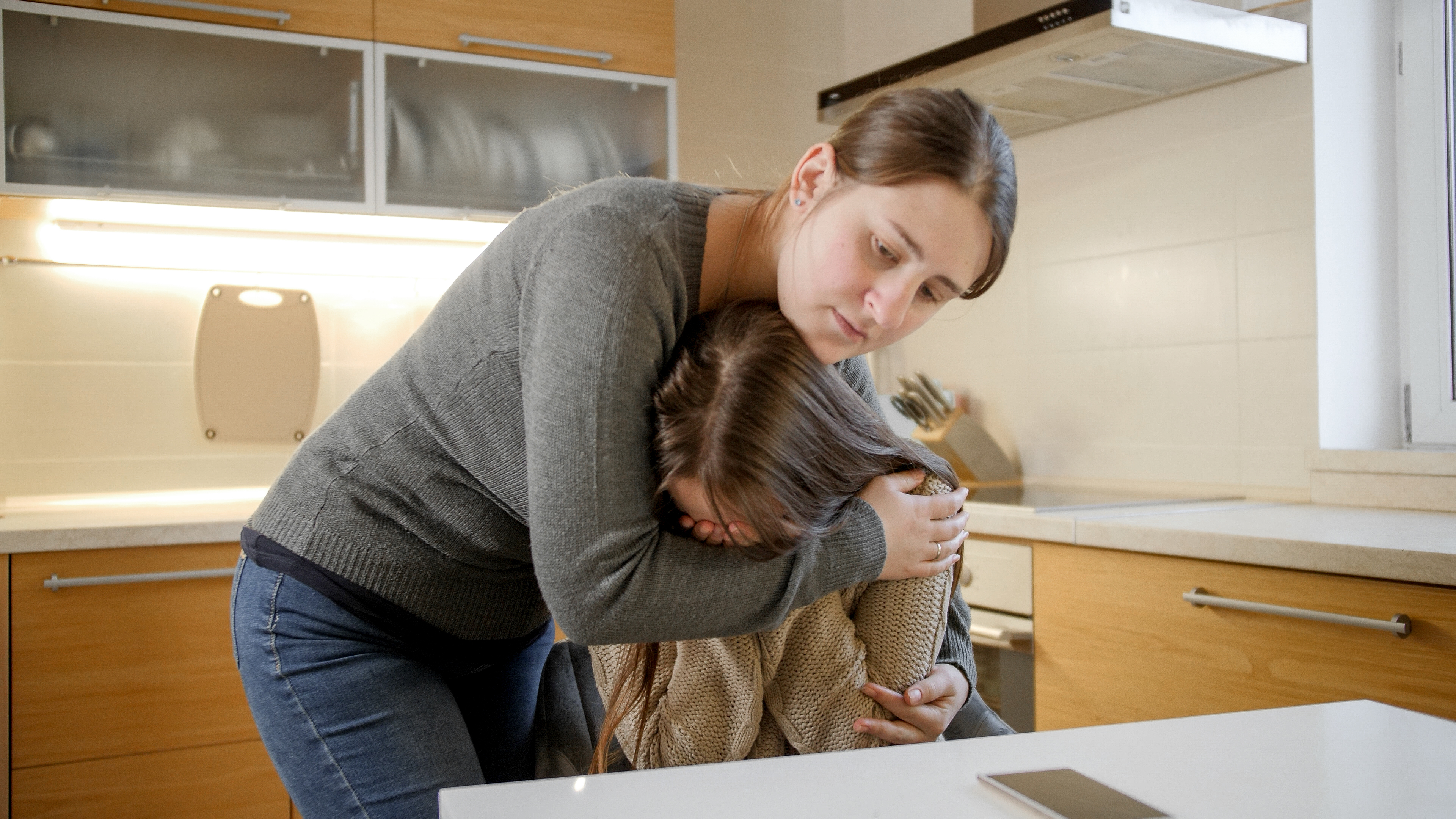 Una adolescente llora y su madre la consuela | Foto: Shutterstock