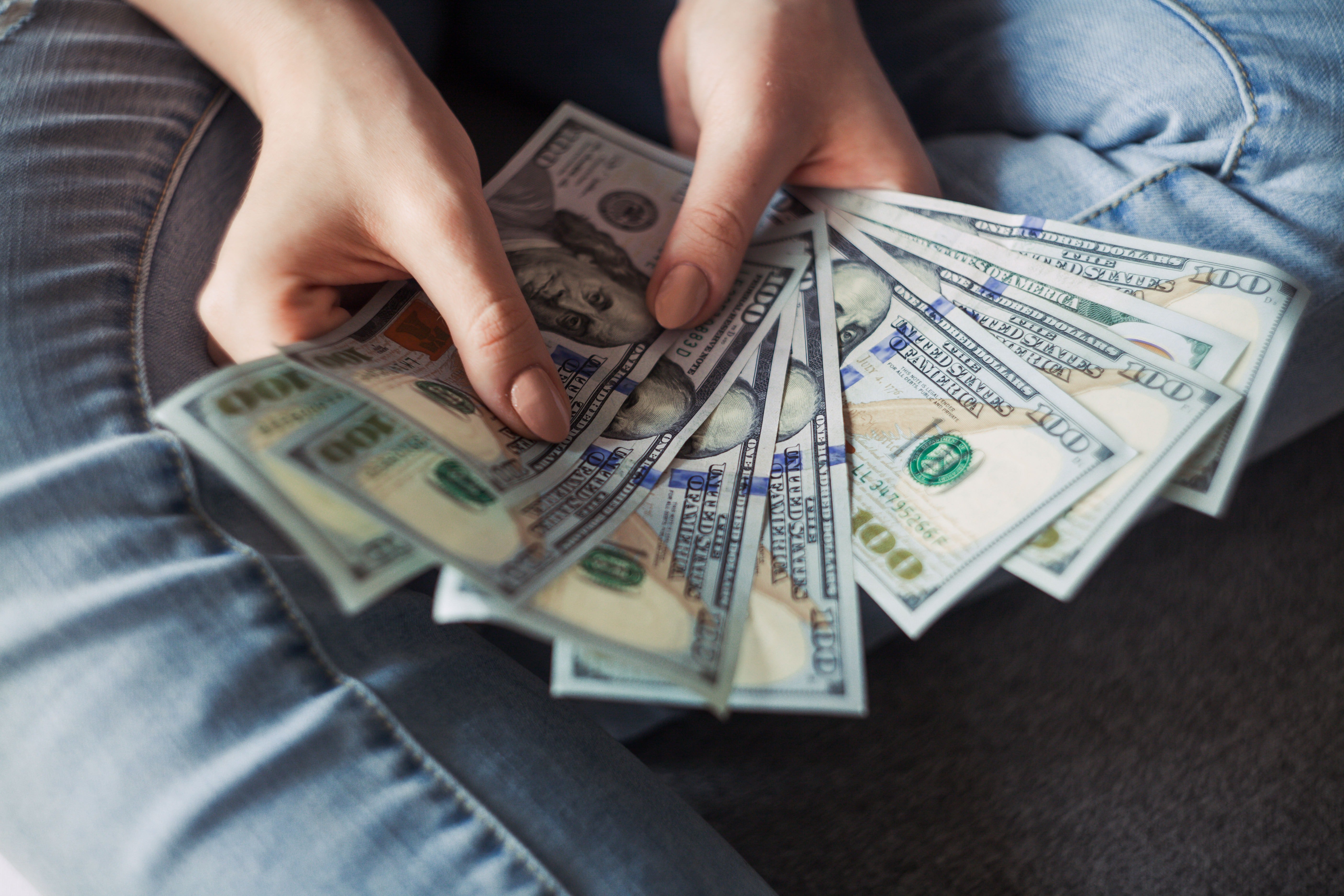 Mujer con varios billetes de 100 dólares en sus manos. | Foto: Pexels