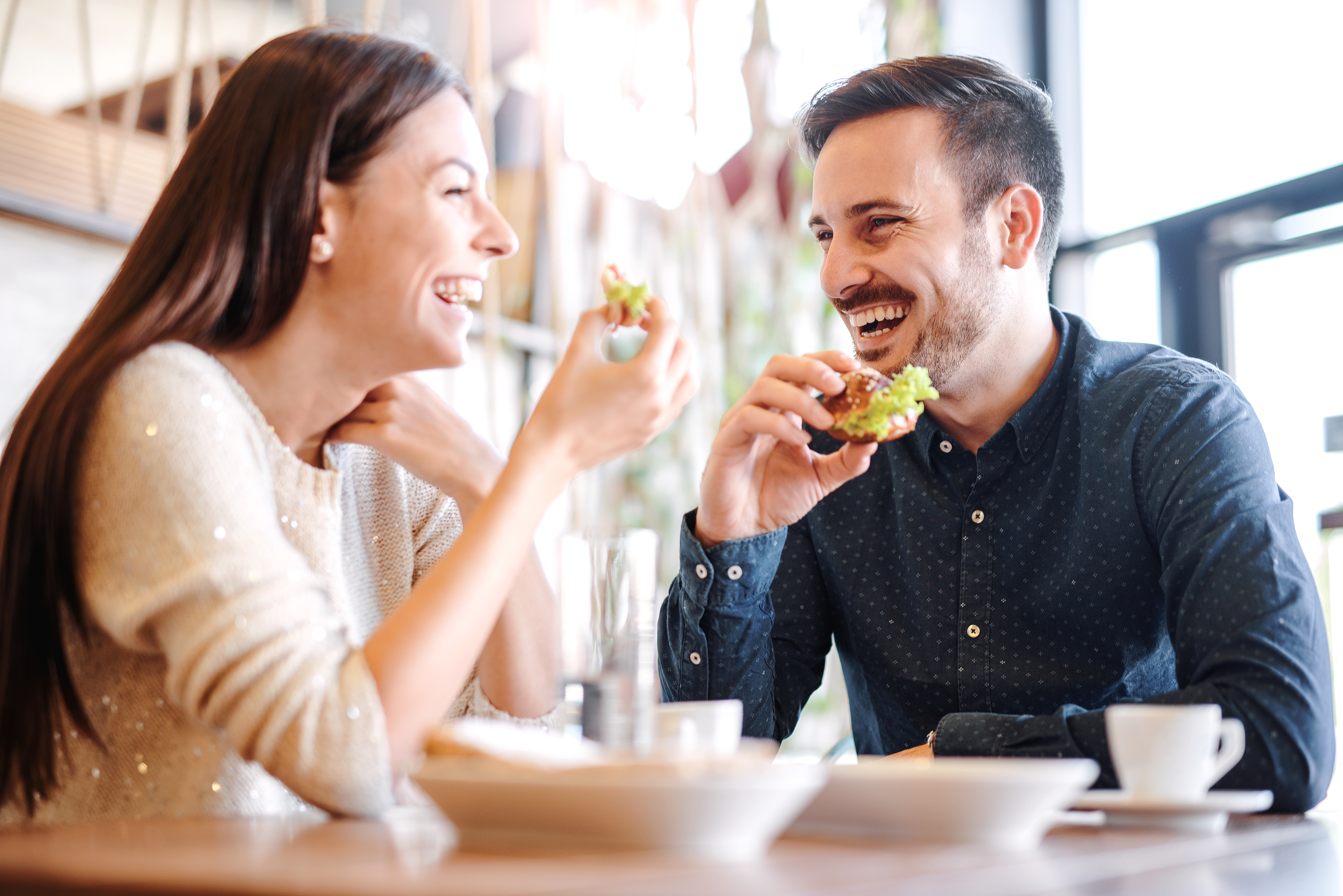 Una pareja riendo mientras disfrutan juntos de una comida | Foto: Shutterstock