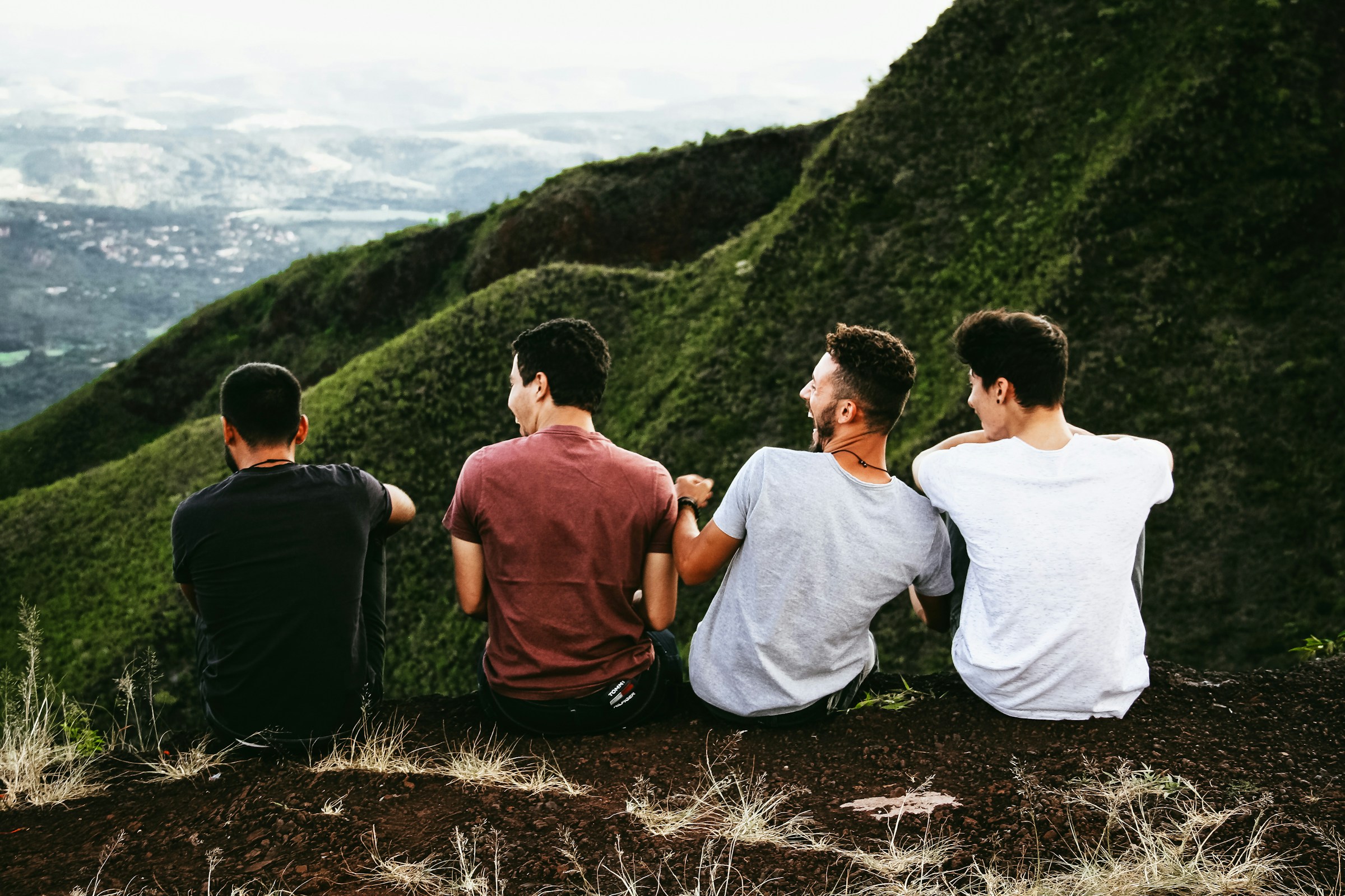 Cuatro jóvenes sentados en un sendero de montaña | Fuente: Unsplash