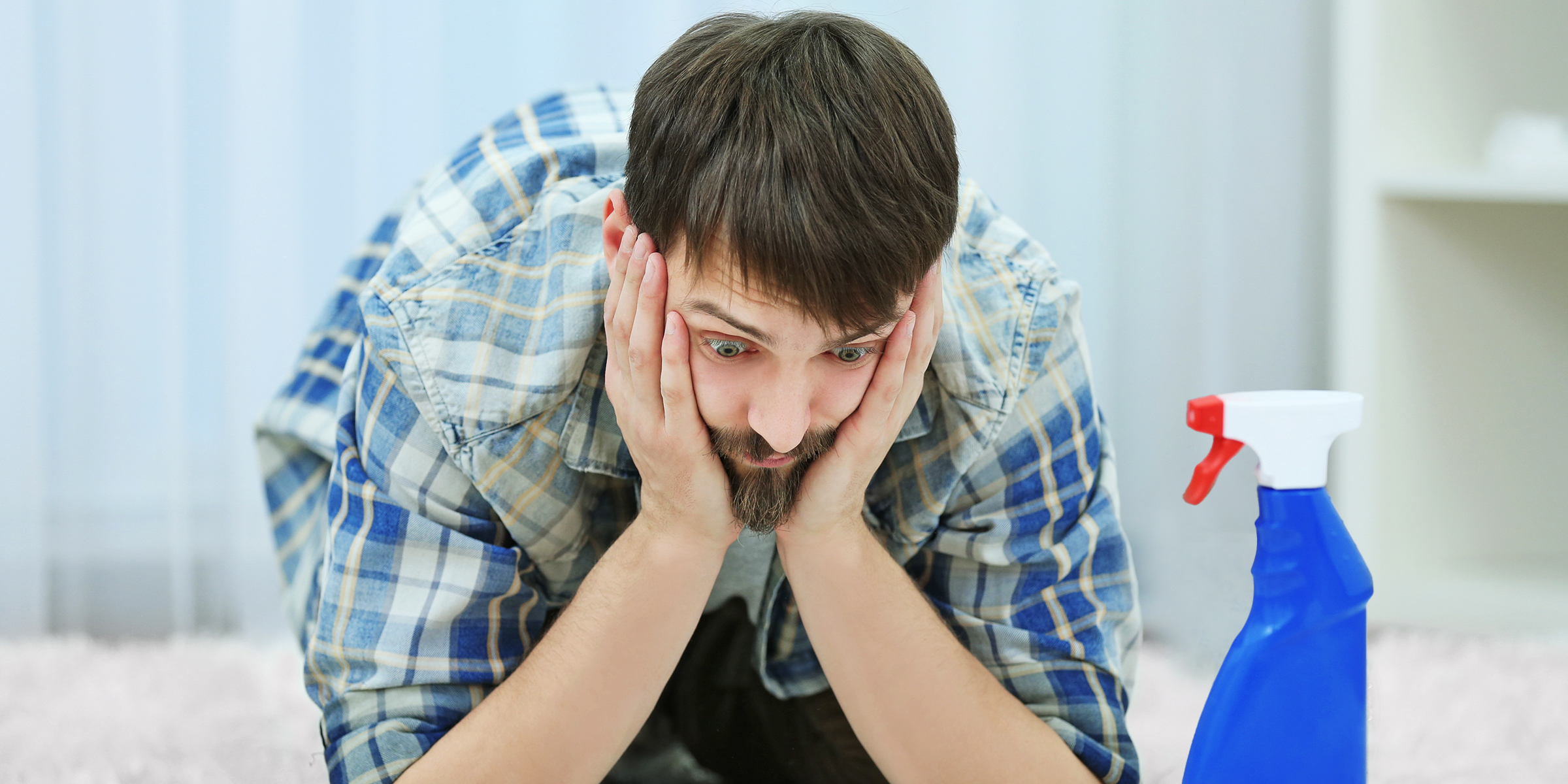 Un hombre confuso viendo una botella de limpiador | Fuente: Shutterstock