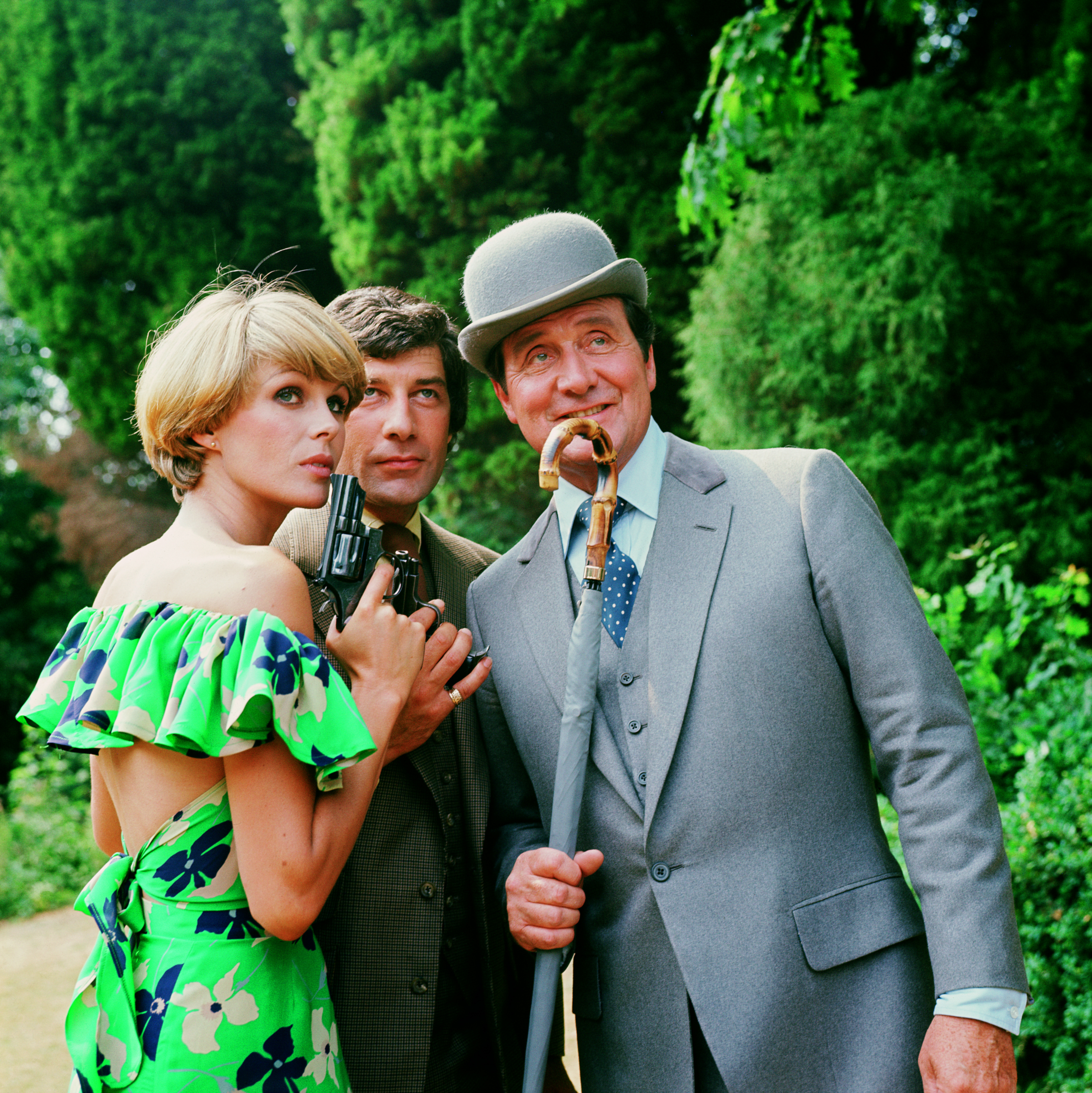 La actriz posa con Patrick MacNee y Gareth Hunt, en los Estudios Pinewood, Londres, Inglaterra, el 12 de julio de 1976 | Fuente: Getty Images