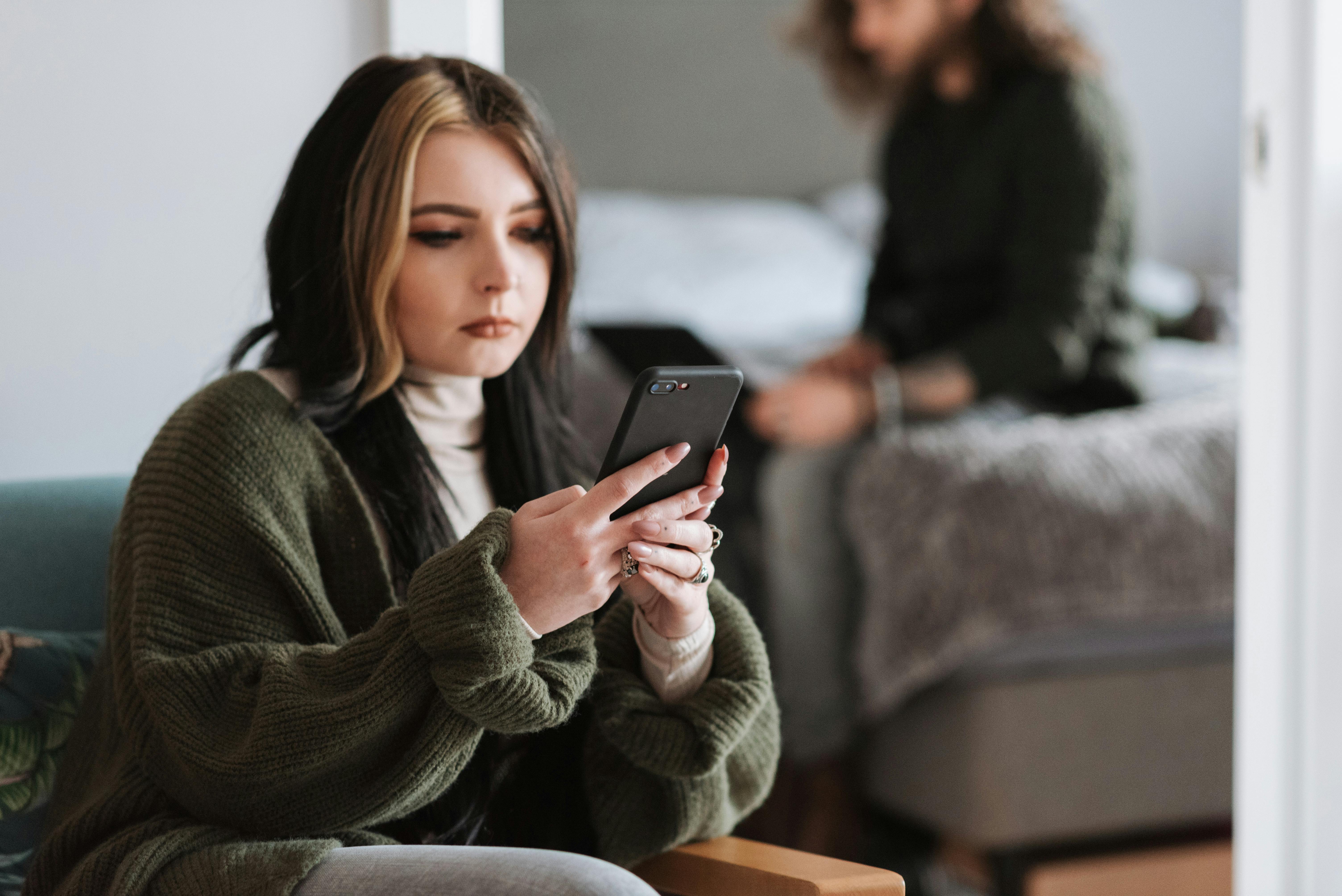 Una mujer hojeando su teléfono | Fuente: Pexels