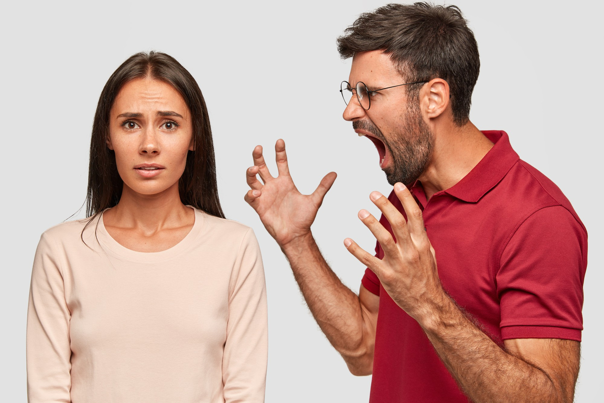 Un hombre enfadado gritando a una mujer de aspecto culpable | Fuente: Freepik