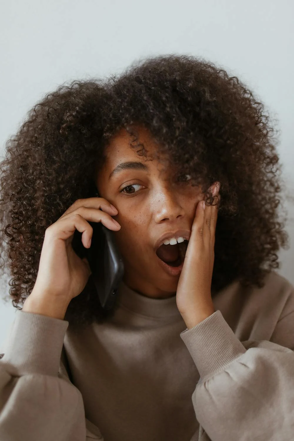 Mujer conmocionada hablando por teléfono | Fuente: Pexels