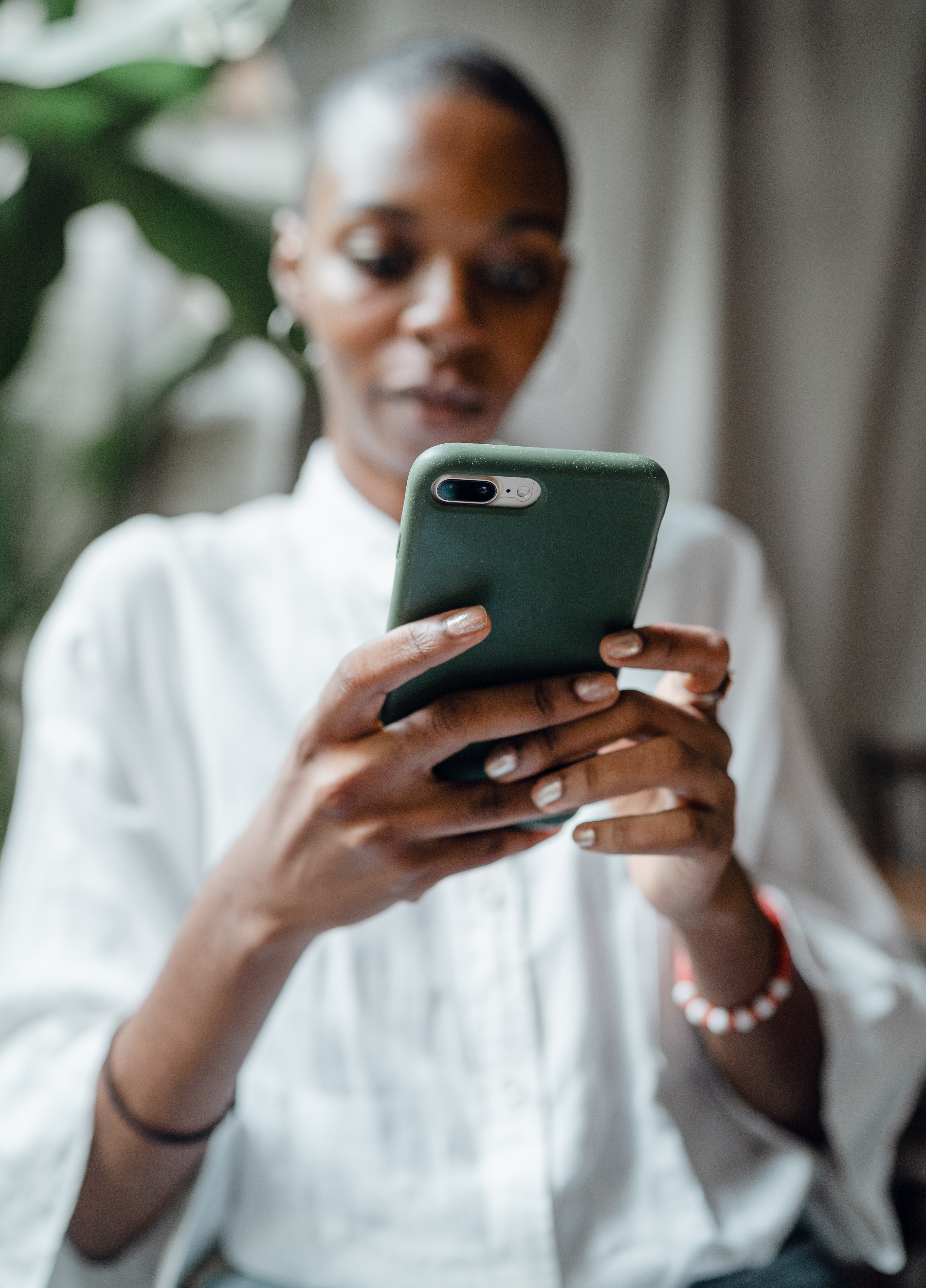 Mujer negra leyendo mensajes en el teléfono | Fuente: Pexels