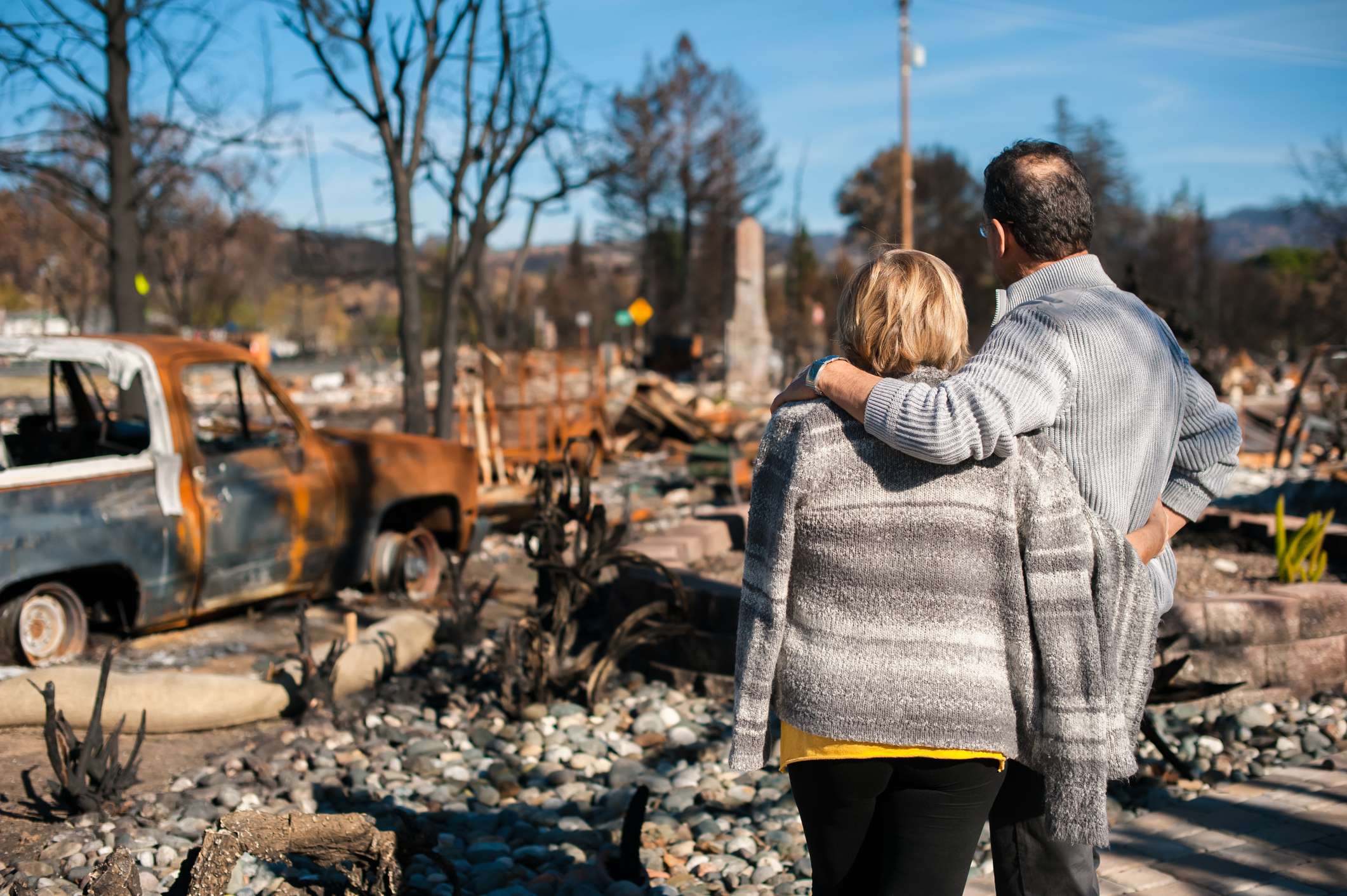 Pareja mirando una casa quemada | Foto: Getty Images