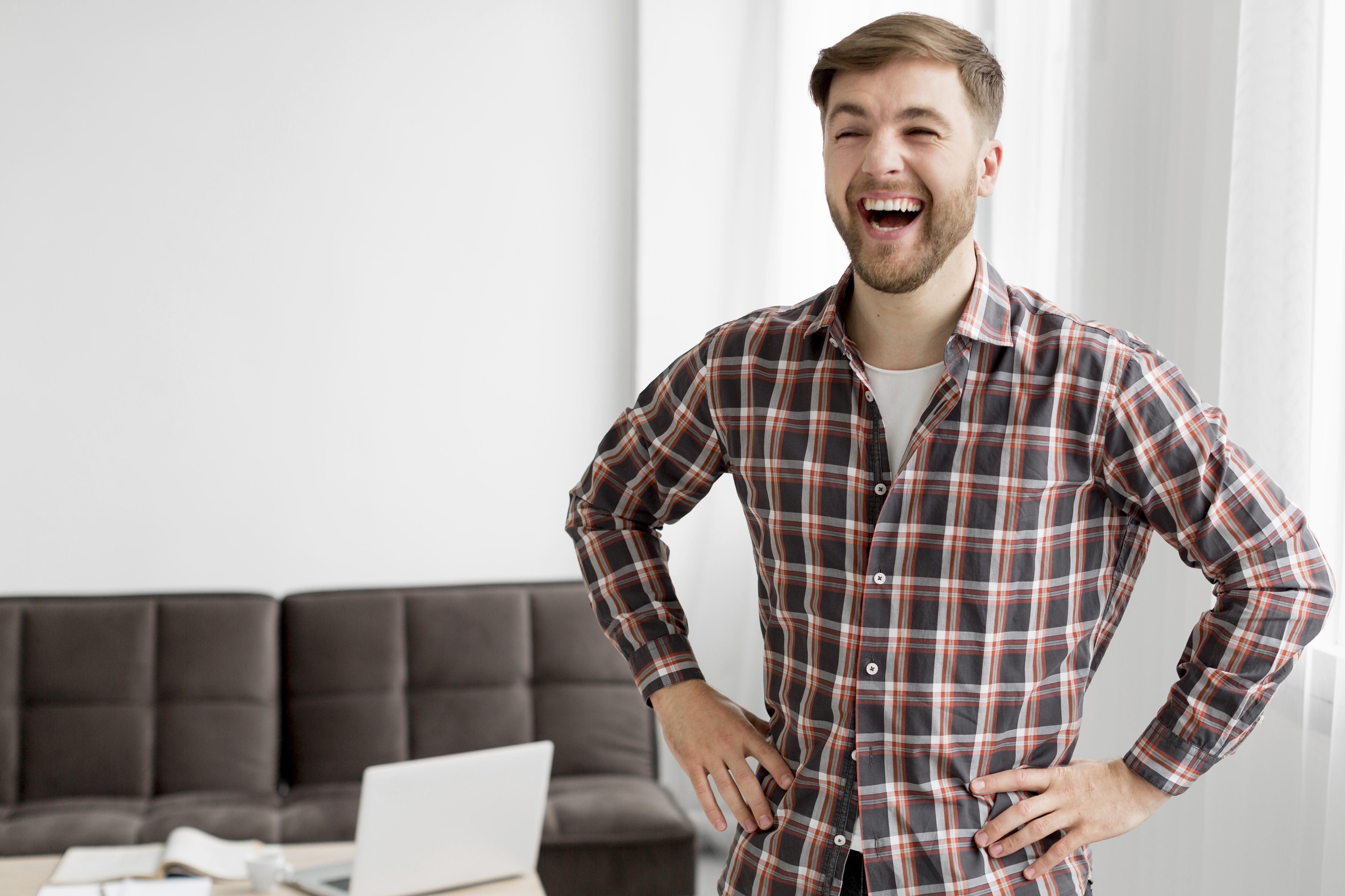 Un hombre riendo con las manos en la cadera | Fuente: Freepik