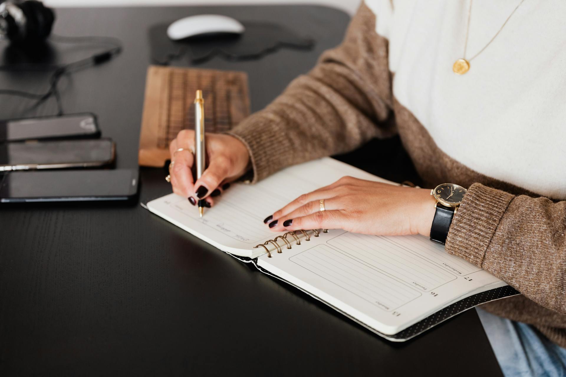 Una mujer escribiendo en una agenda | Fuente: Pexels