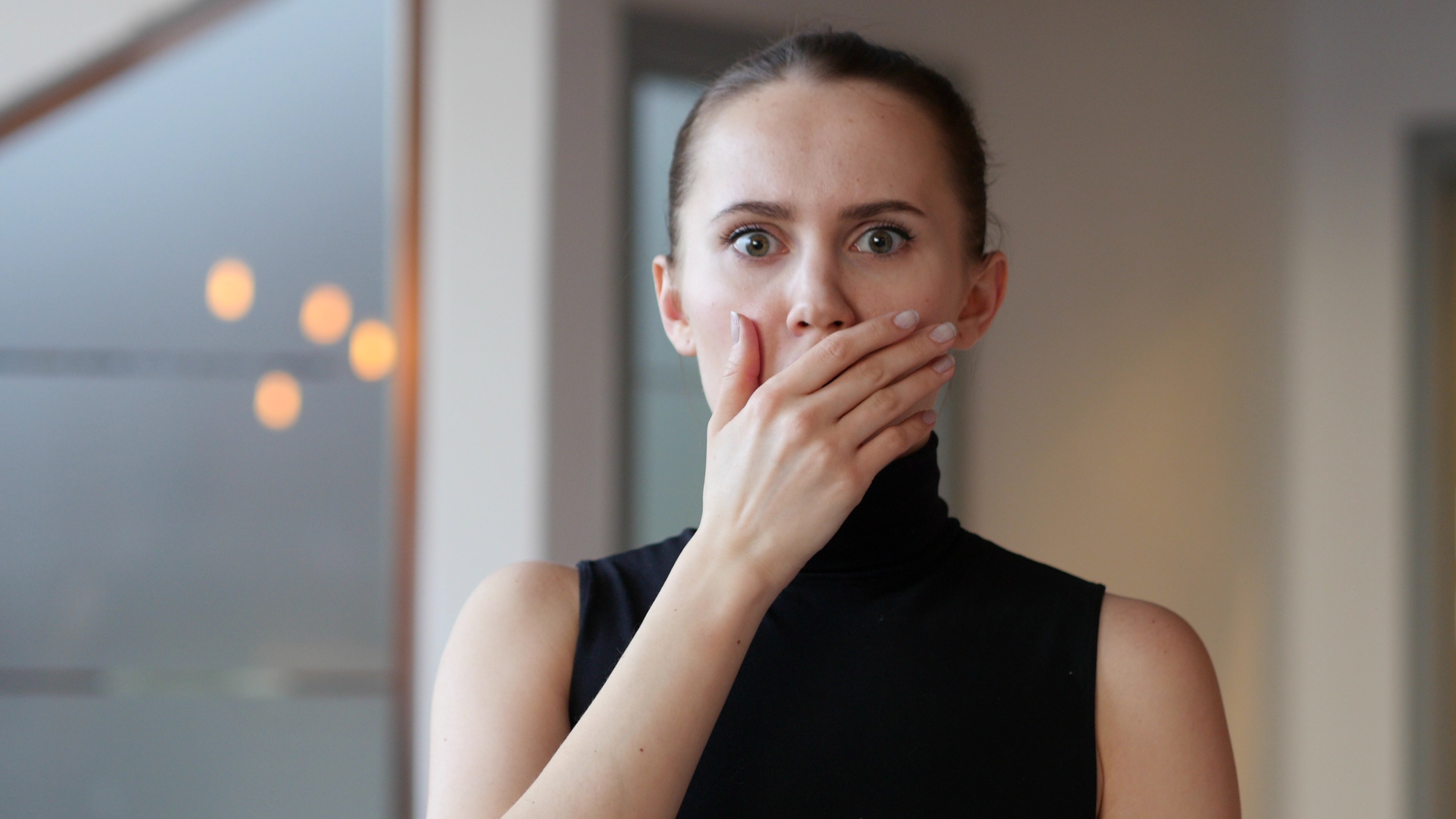 Una mujer conmocionada tapándose la boca con la mano | Fuente: Shutterstock