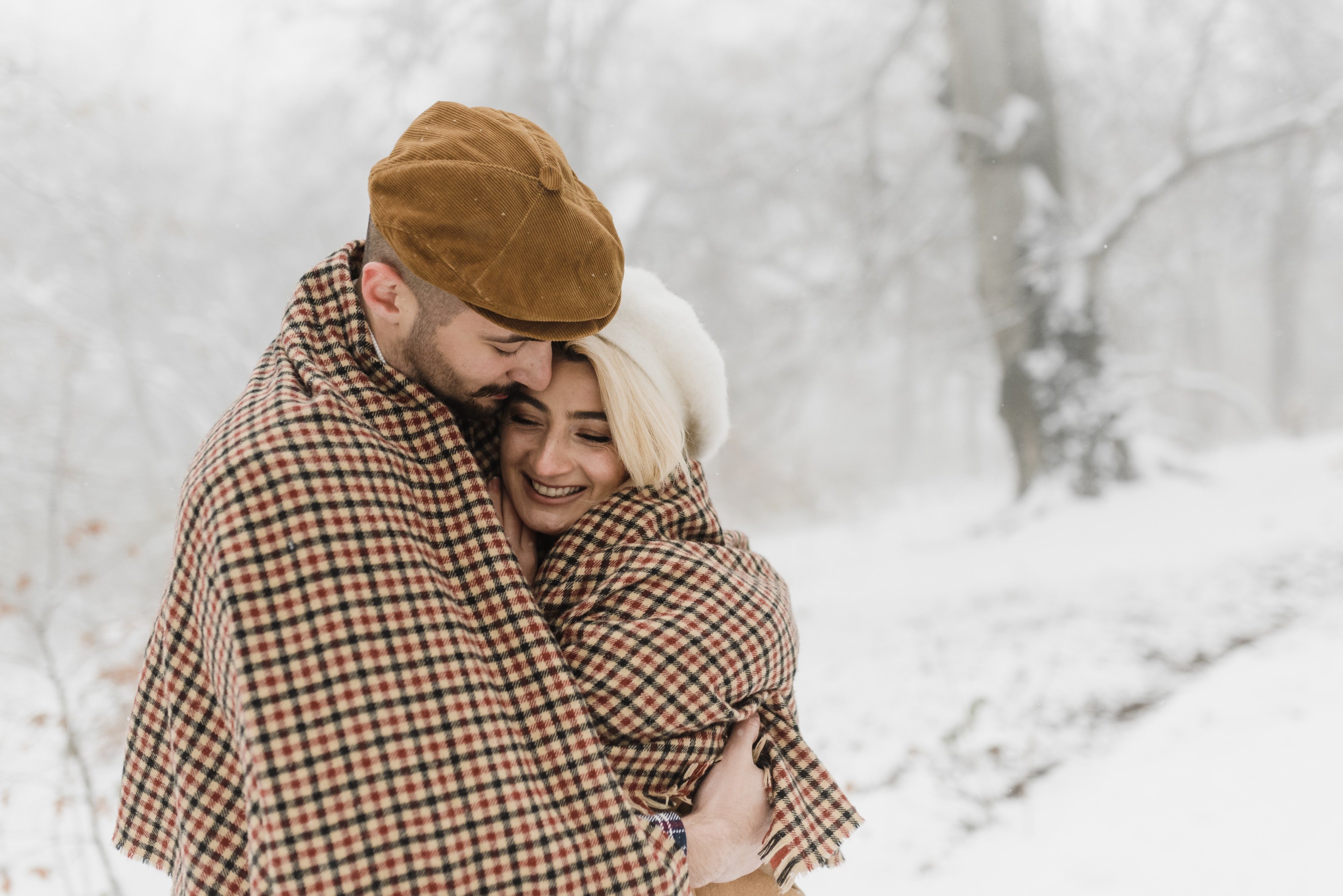 Una pareja se da un abrazo en una calle cubierta de nieve. | Foto: Pexels